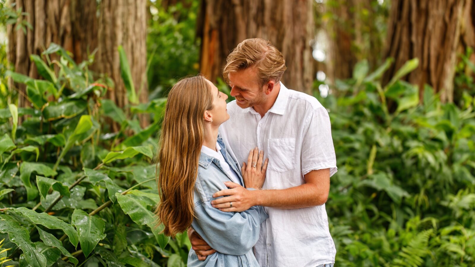 photo of couple holding each and smiling in the woods in Hawaii