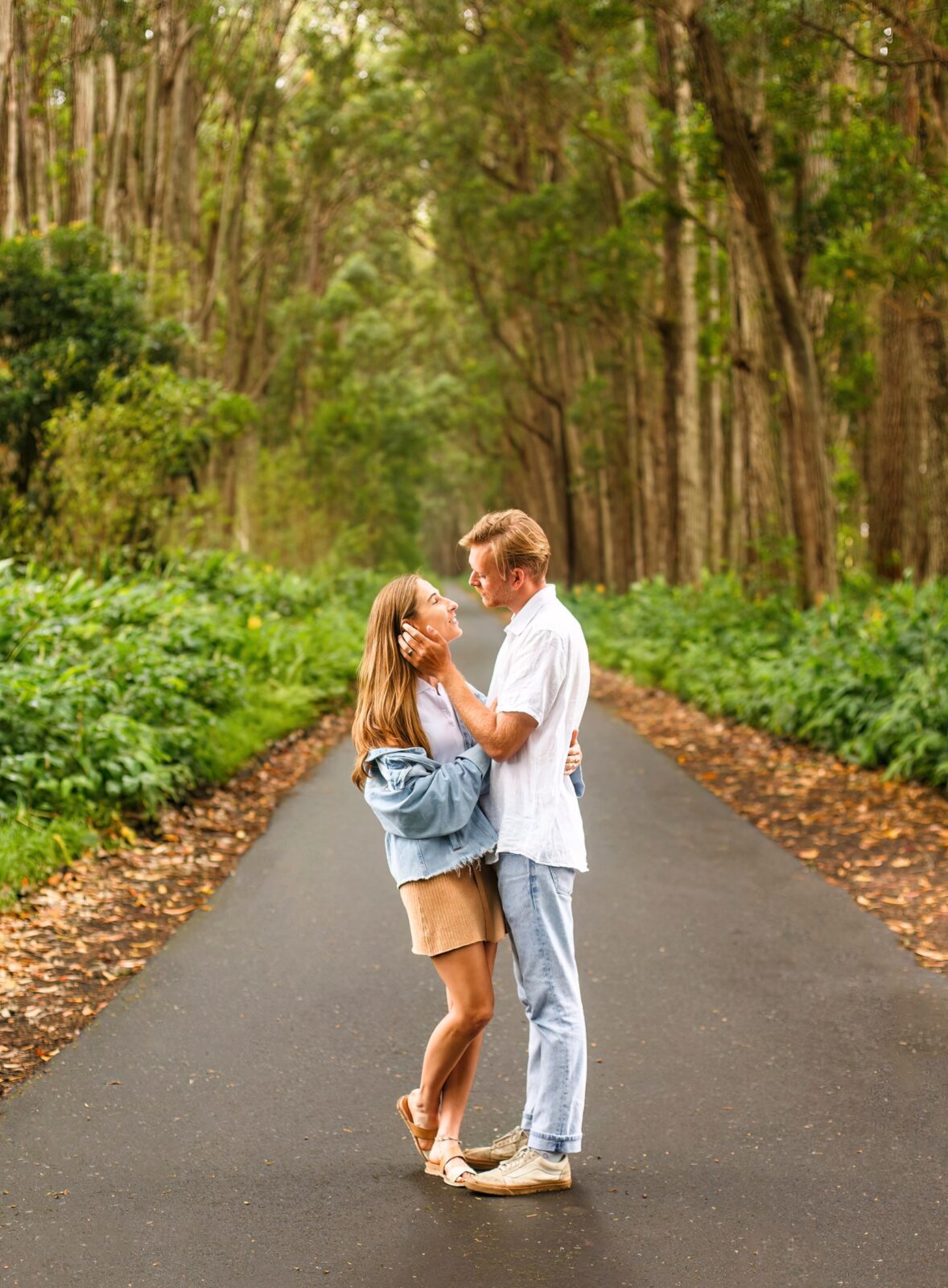 photo of couple standing in the street holding each other as her brushes her hair away