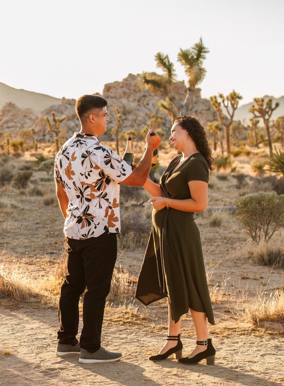 photo of couple cheersing with champagne in desert