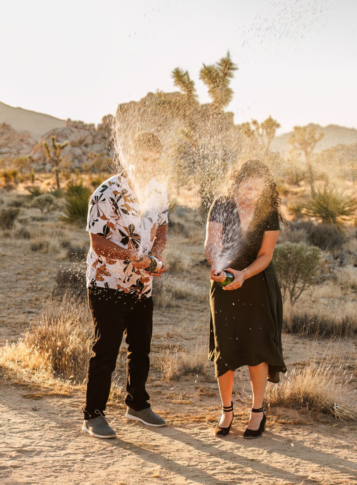 photo of couple spraying champagne at engagement session in Joshua Tree