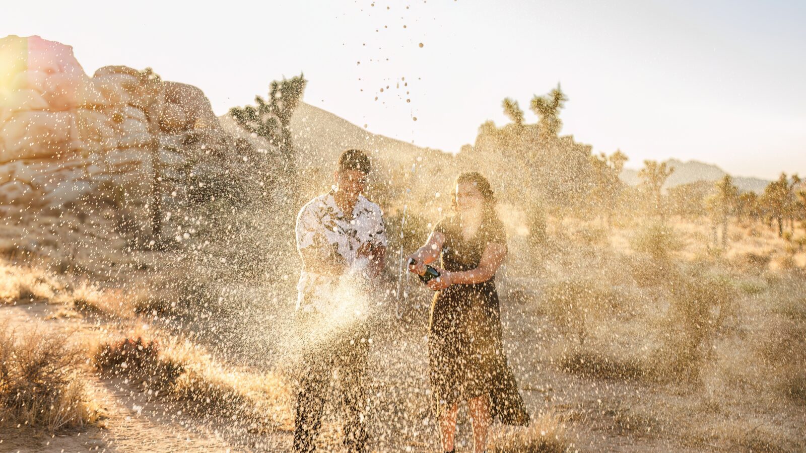 photo of couple in Joshua Tree spraying champagne all over