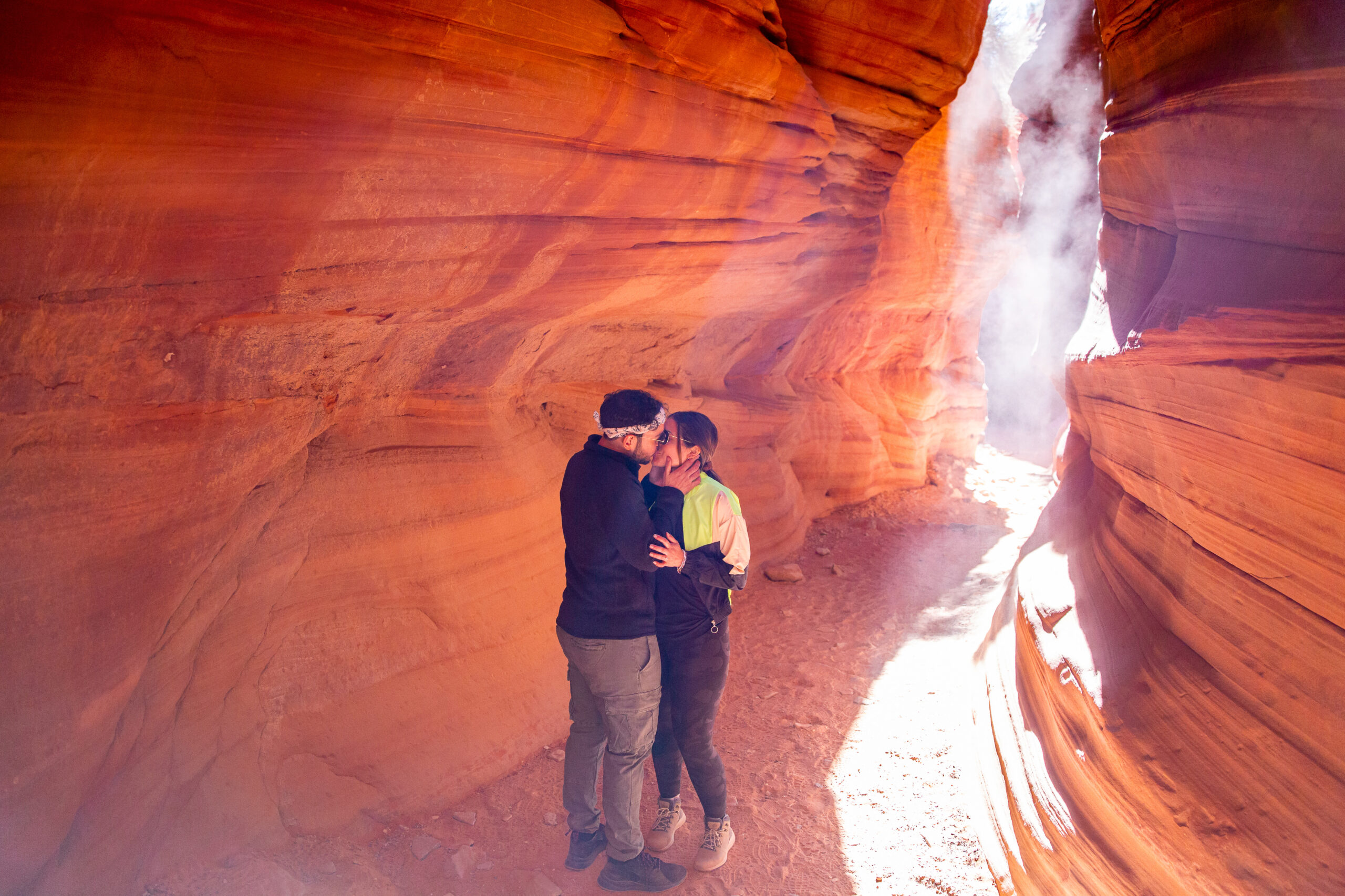 a couple kissing in the canyons with a fog rolling through it 