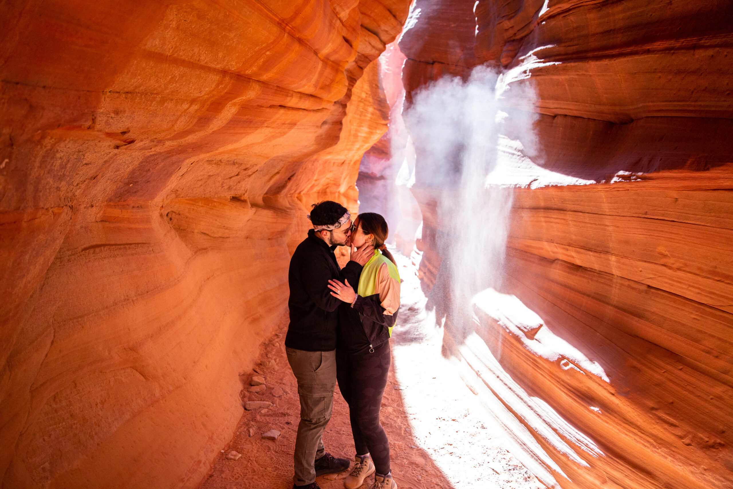 a couple kissing in a canyon after they got engaged