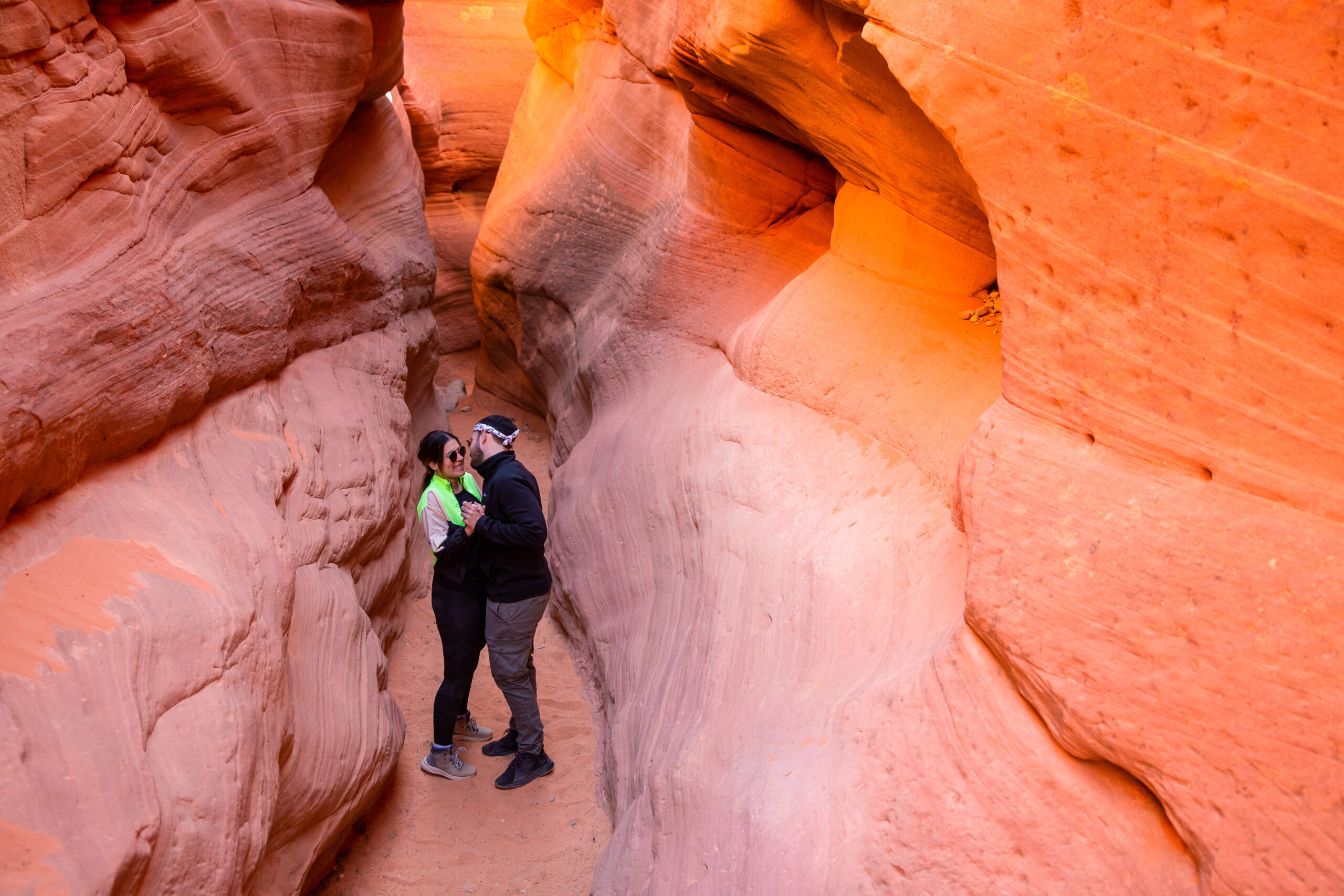 a couple smiling at each other in a canyon in Utah after their engagement 