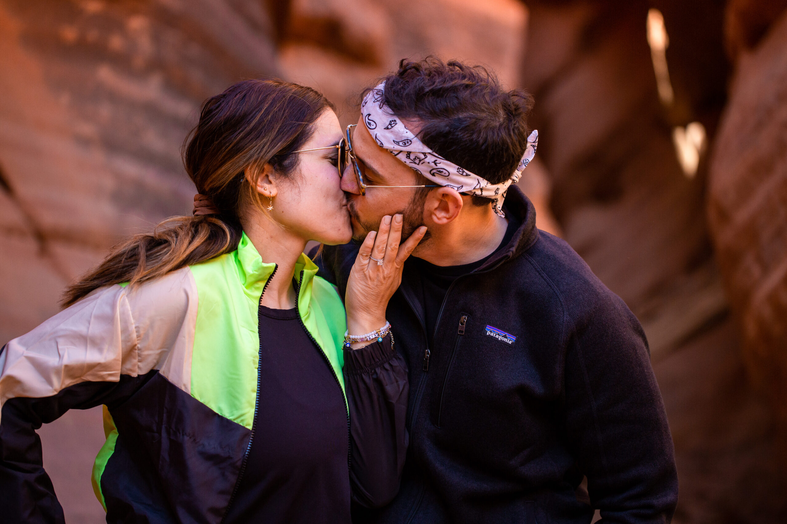 a newly engaged couple kissing after the planned proposal 