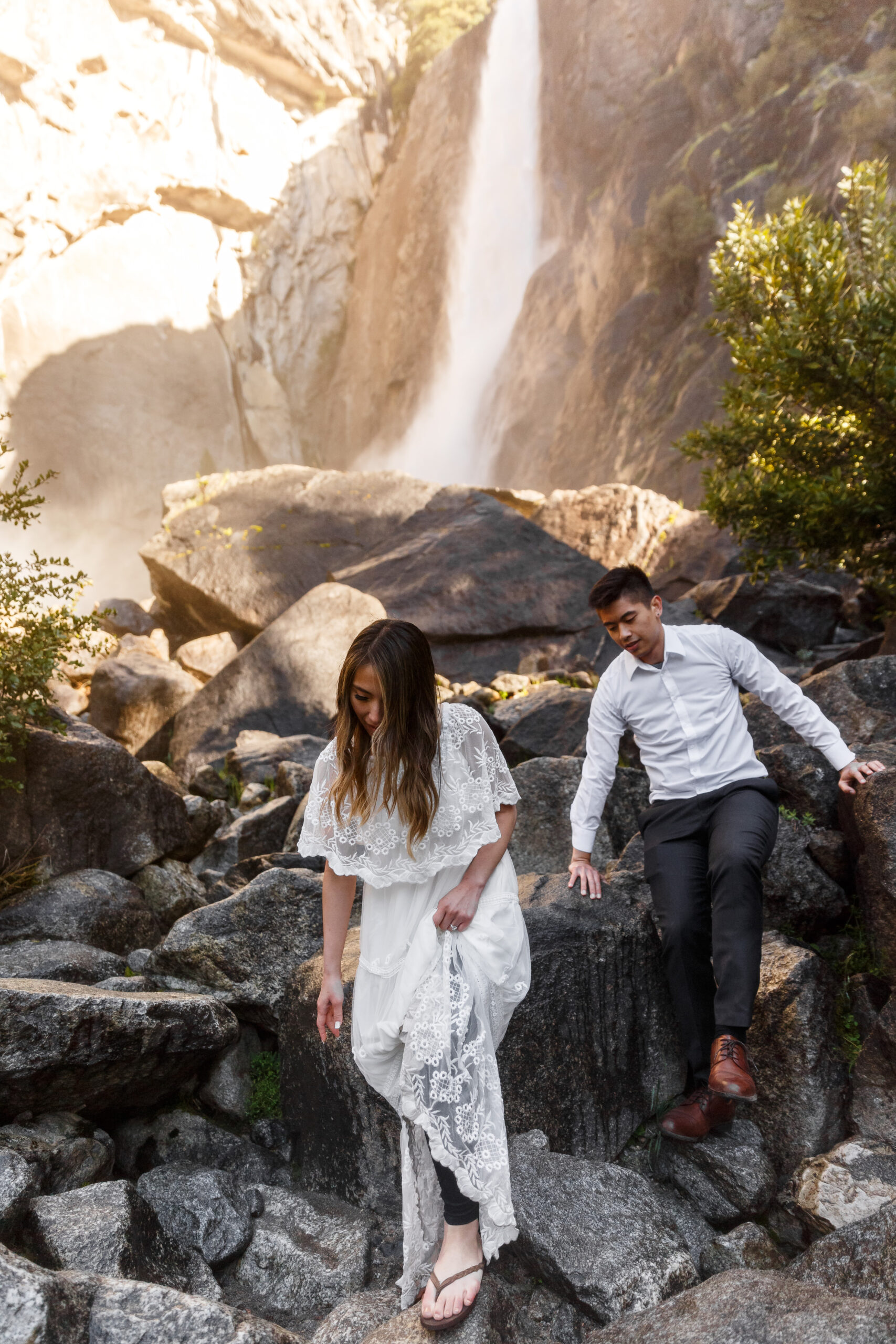 a couple walking through the walks away from the waterfall 