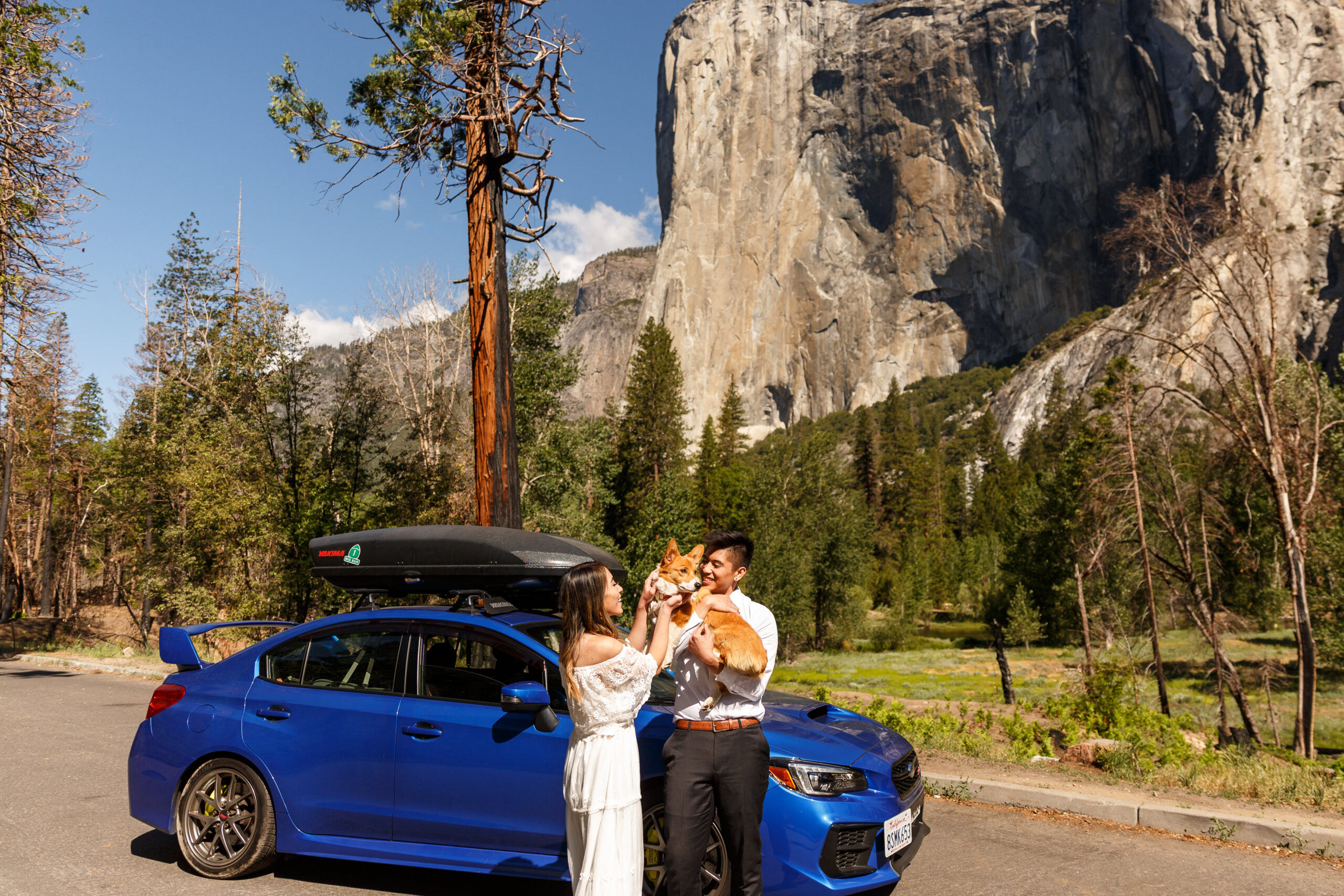 married couple holding their dog by their car during an After Wedding Photoshoot