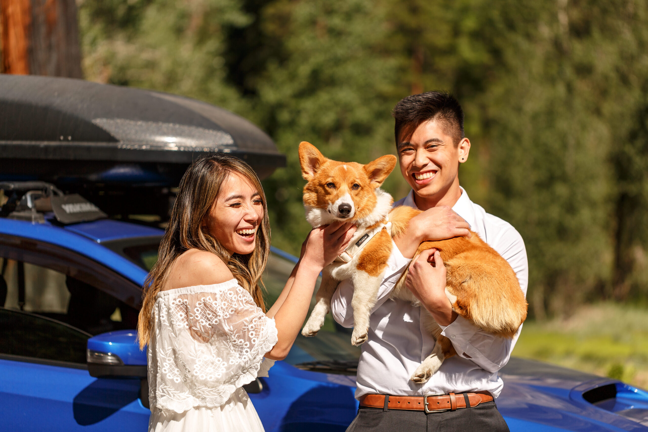 a couple laughing and holding their dog in Yosemite 