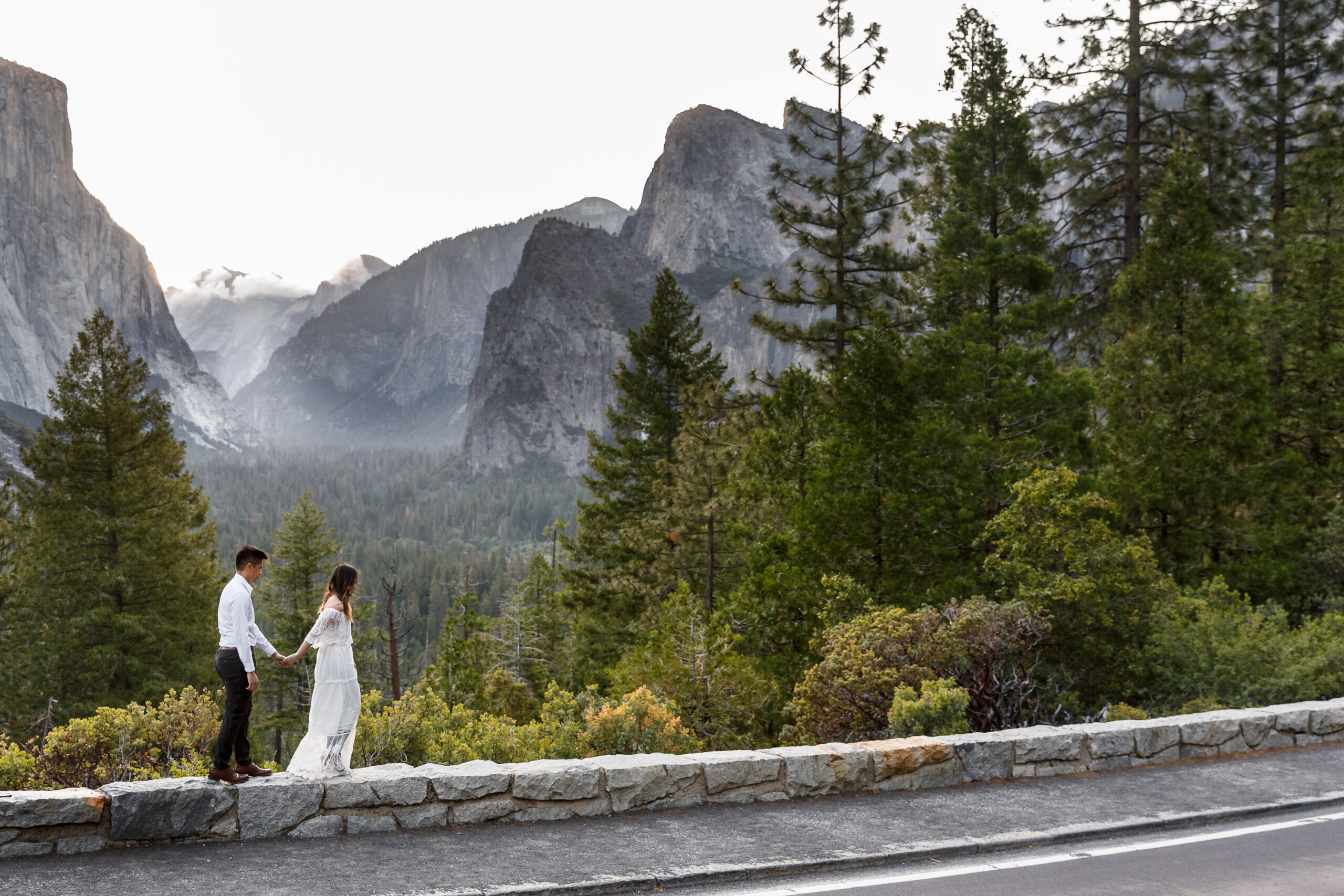 a couple walking hand in hand on a ledge in Yosemite during an After Wedding Photoshoot