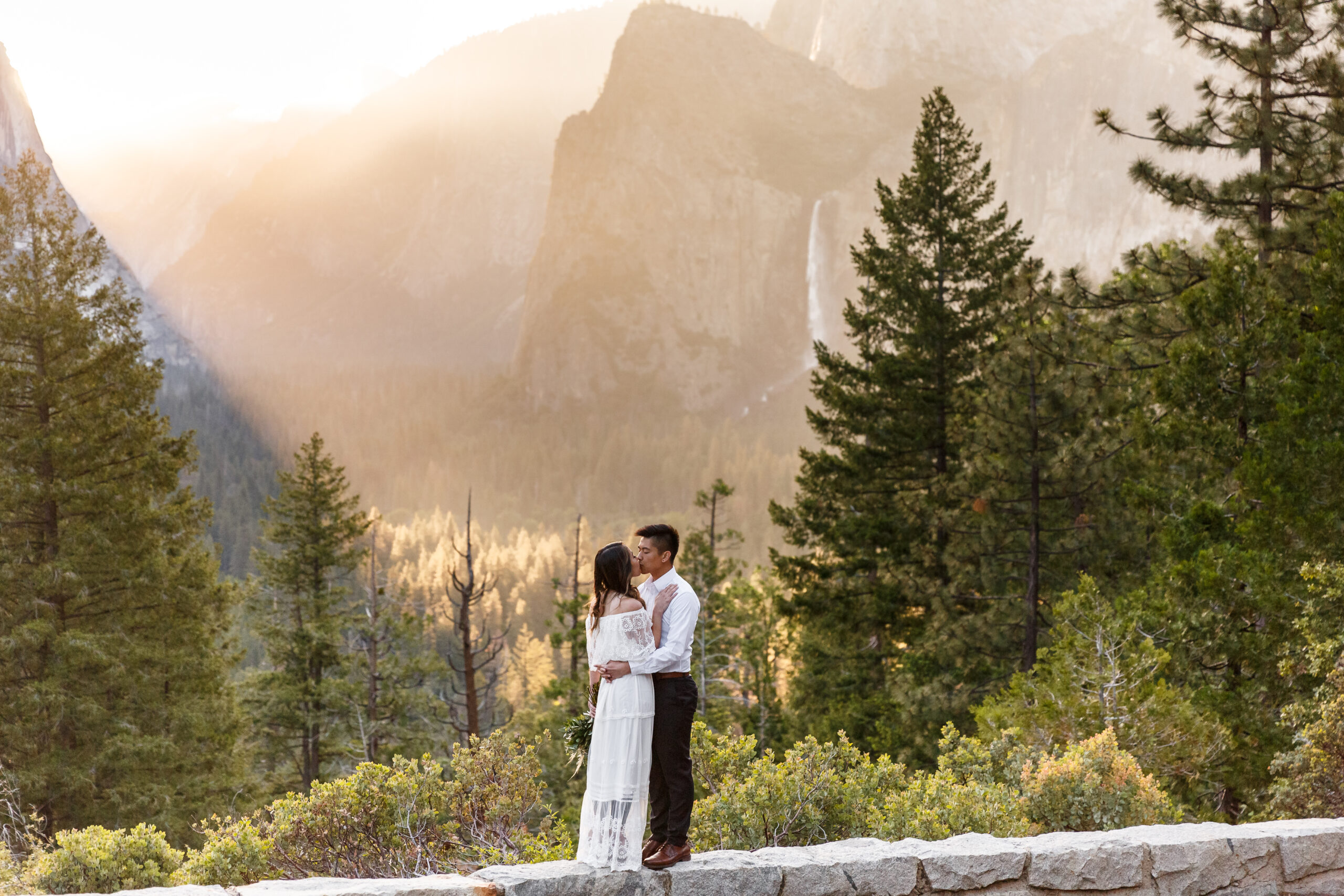 a couple kissing on a ledge during their After Wedding Photoshoot