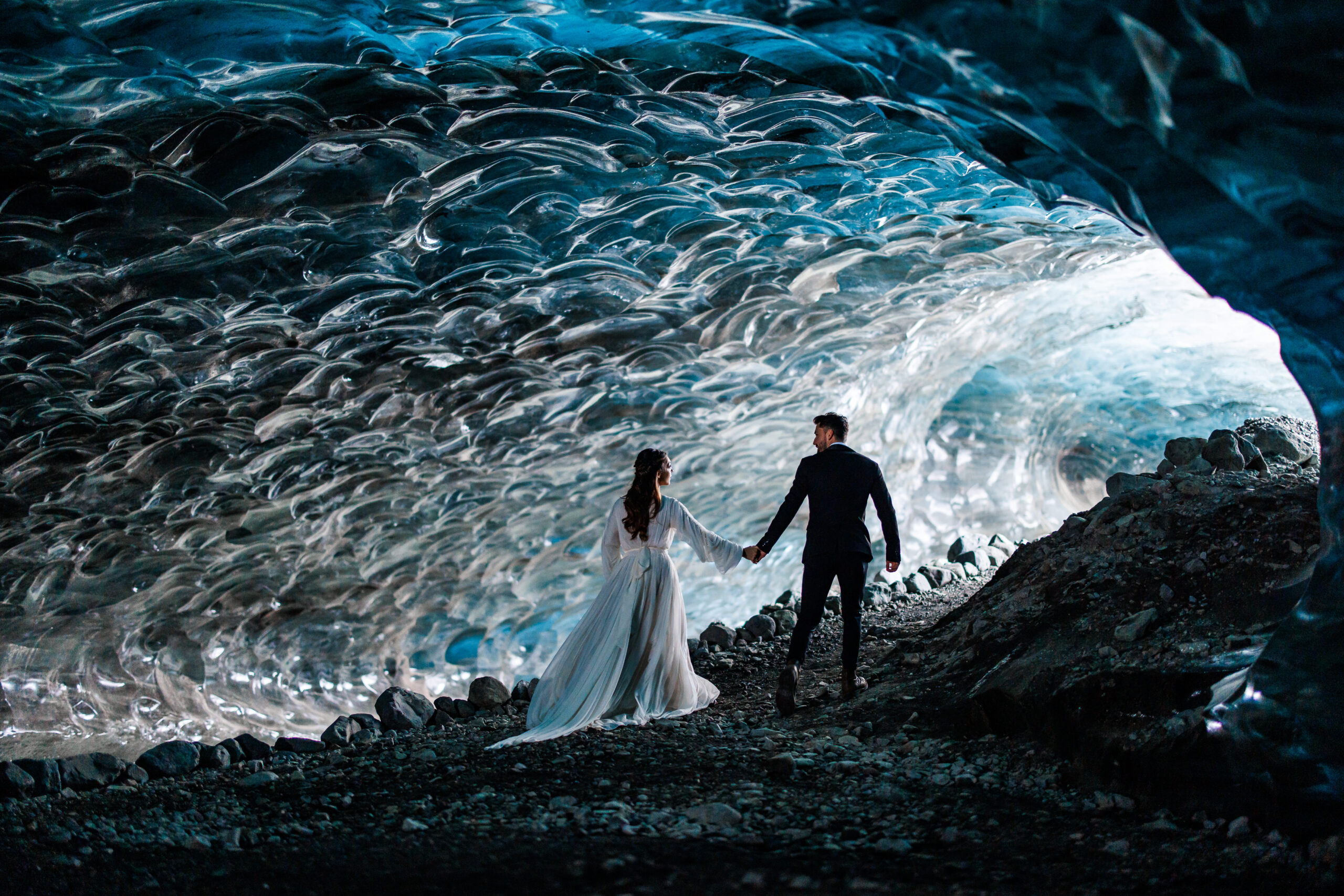 bride and groom walking together through ice caves during a winter elopement