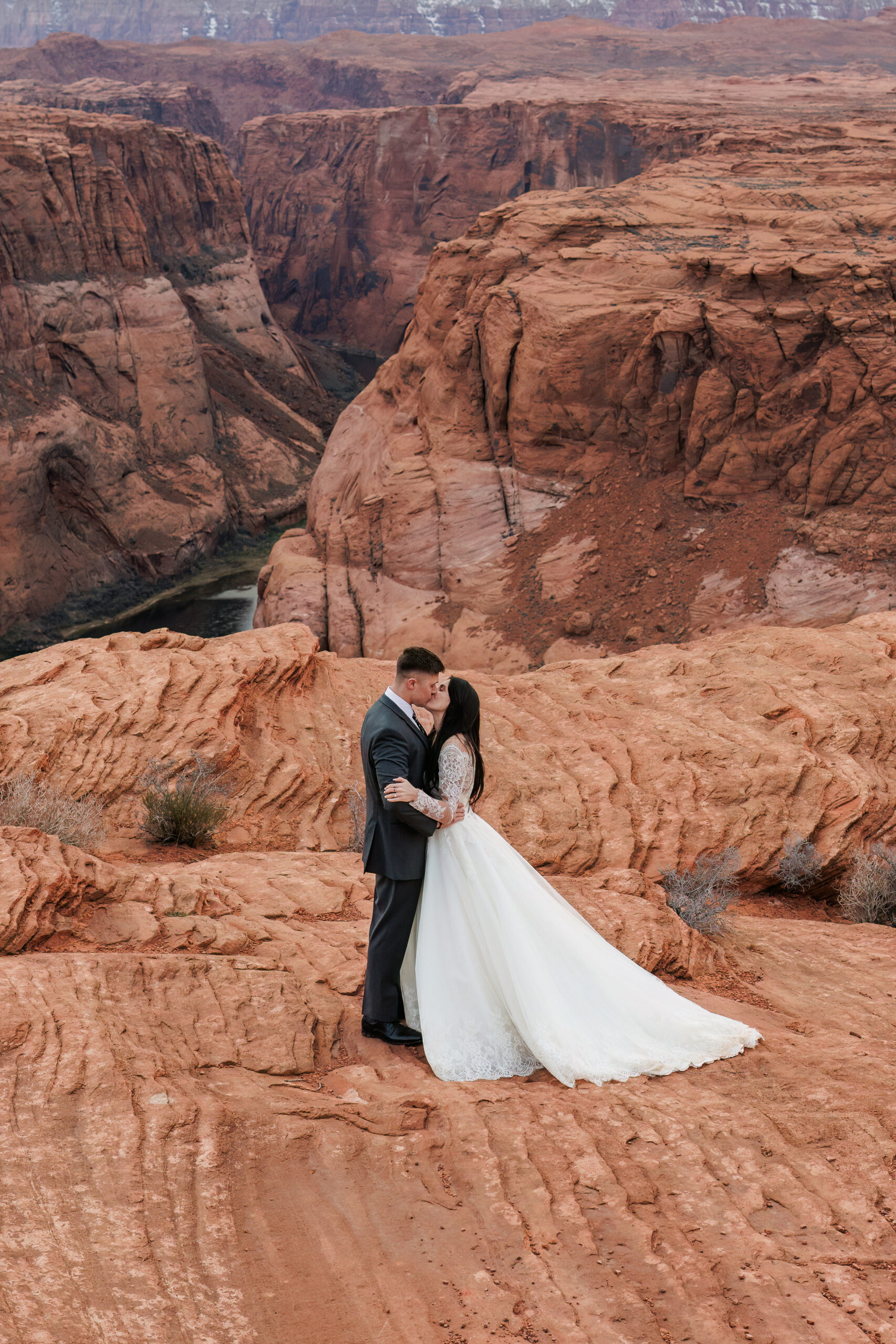 a bride and groom kissing with an epic view of horseshoe bend for their winter elopement