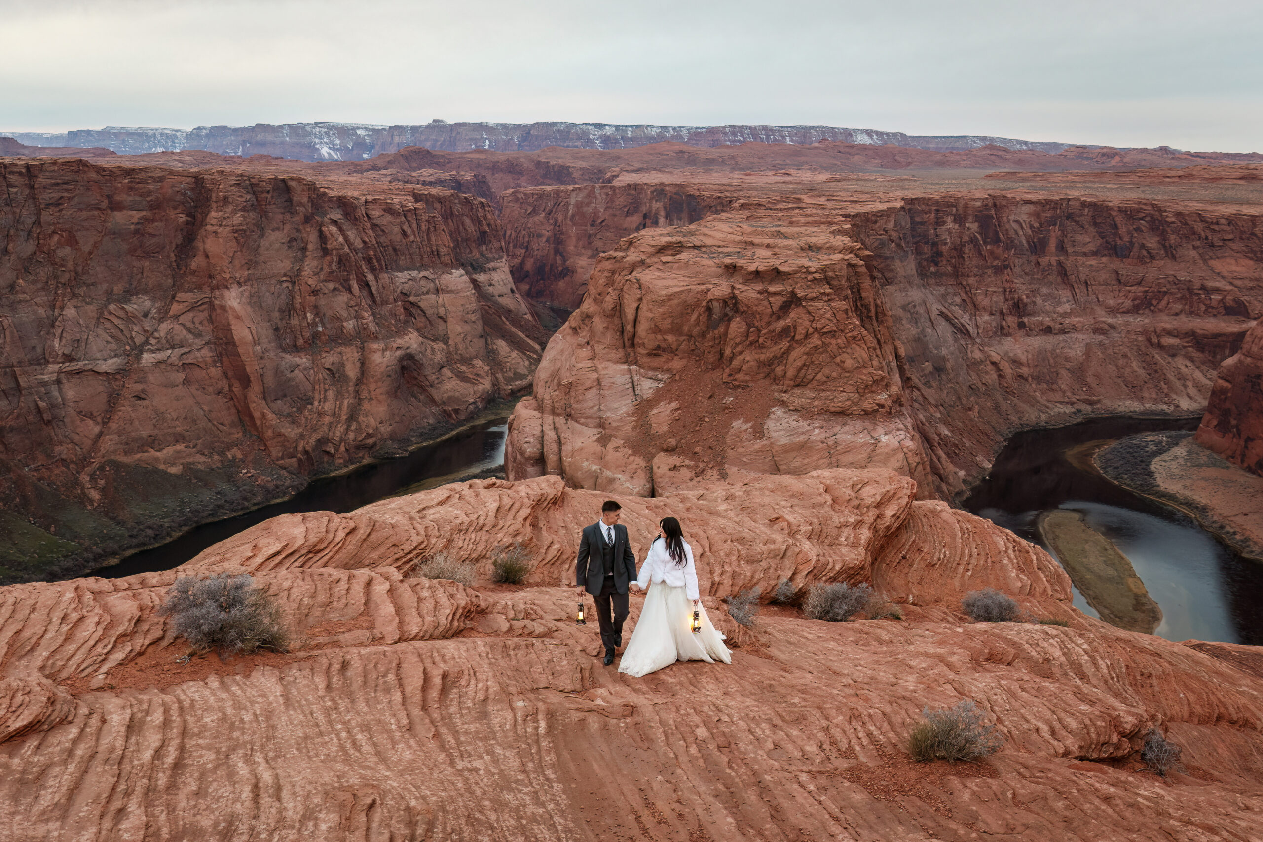 bride and groom holding lanterns and wearing warms clothes for their winter elopement