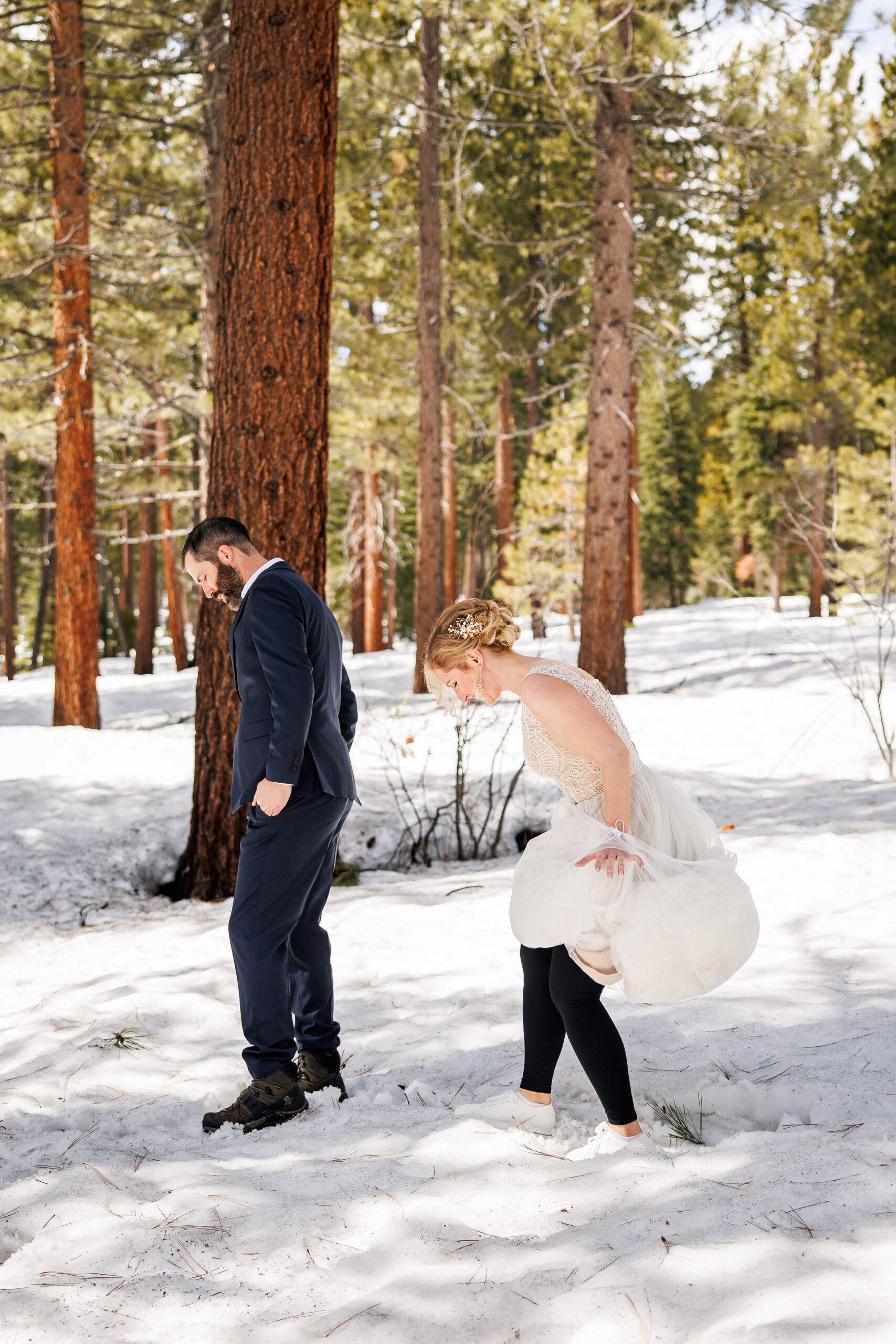 the bride behind the groom adjusting her dress with her leggings underneath 