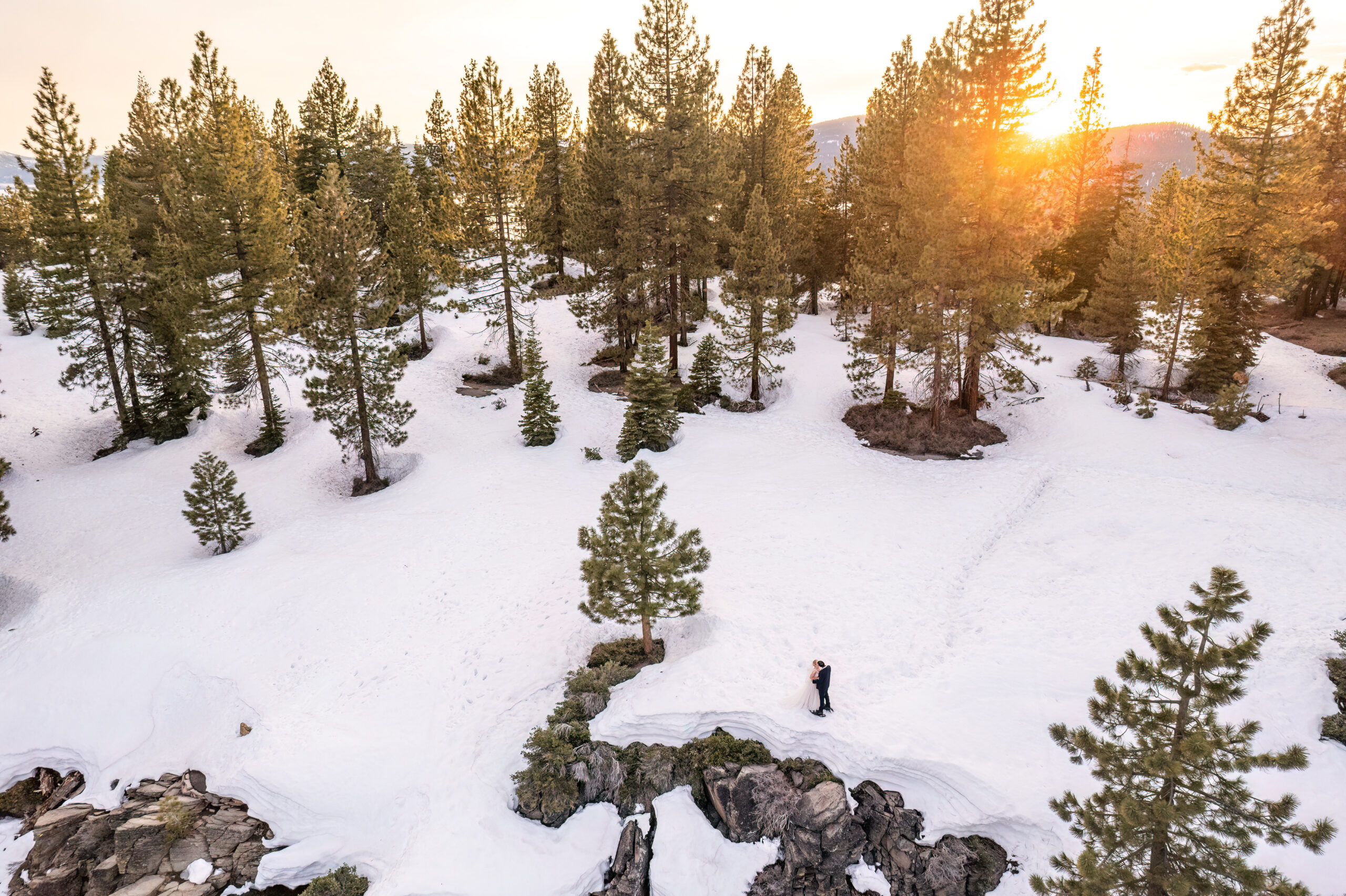 view from above as the couple in embracing in the snowy landscape of Lake Tahoe 