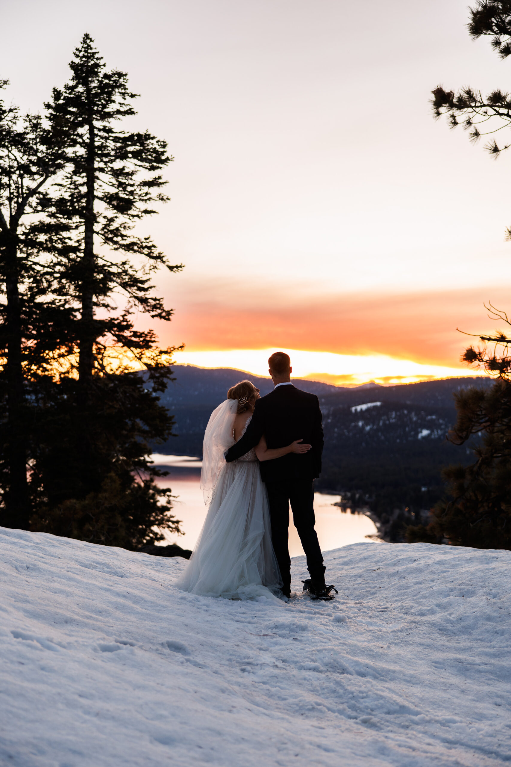 bride and groom snowshoeing in lake Tahoe to get a great sunset view 