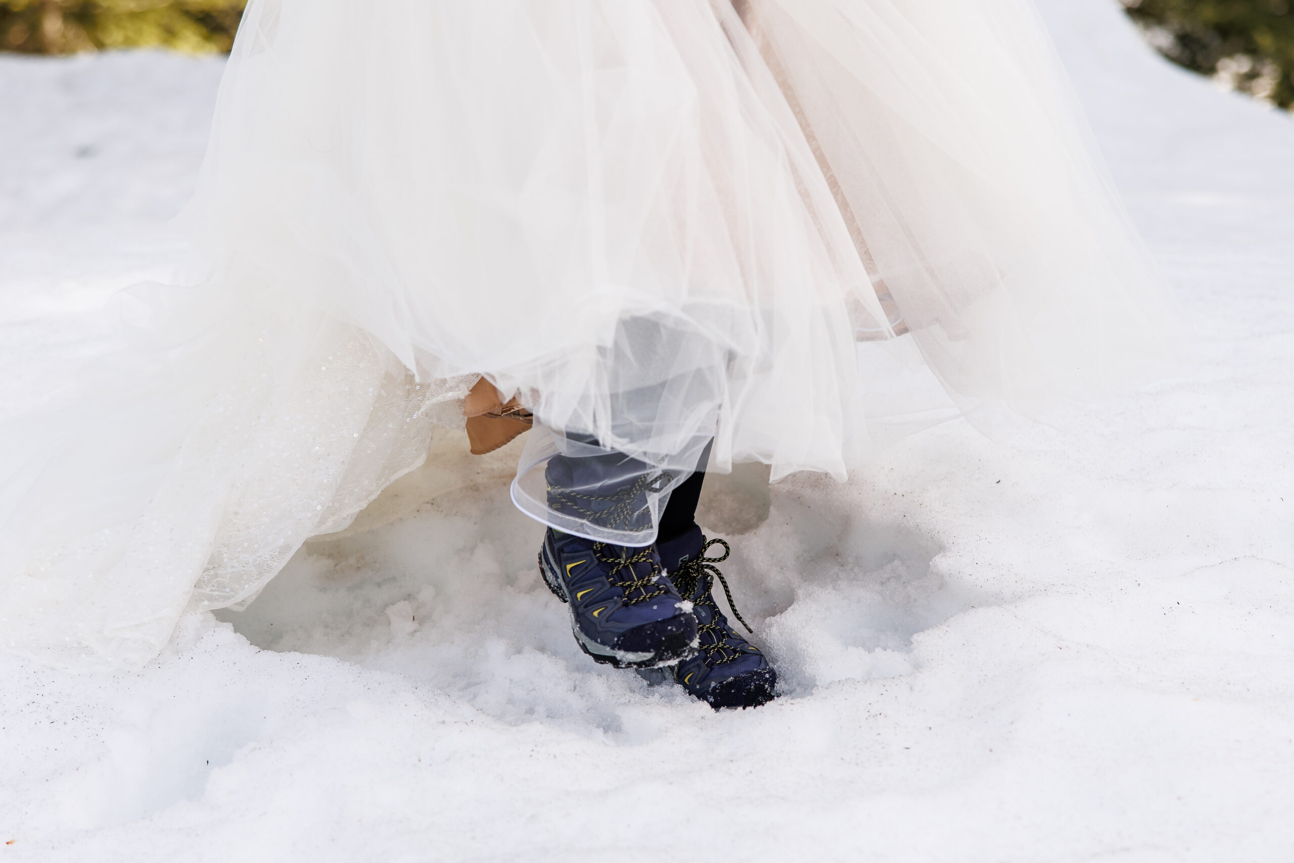 a peak of the bride's winter hiking boots under her dress