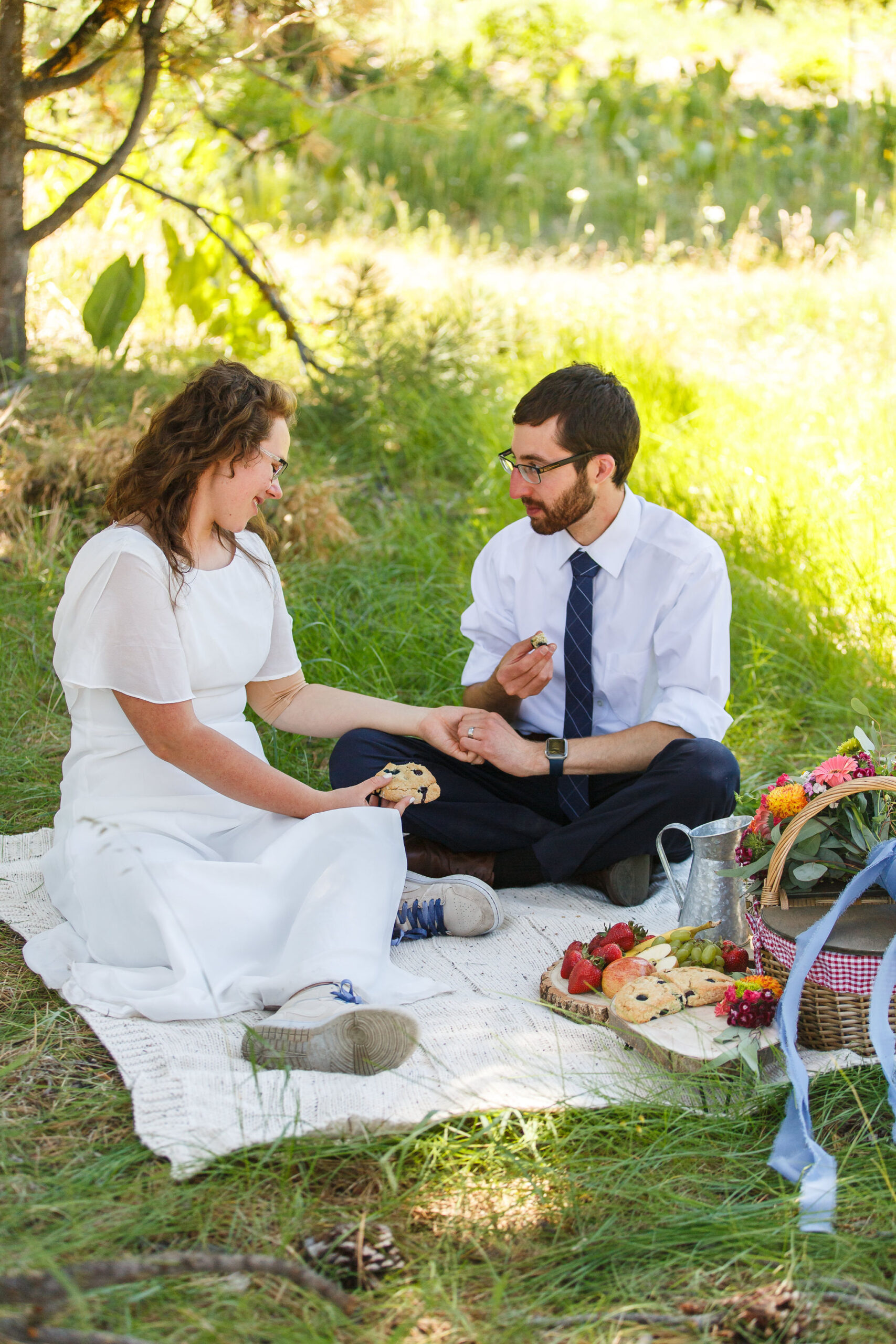 newly weds enjoying a picnic in a wildflower meadow 