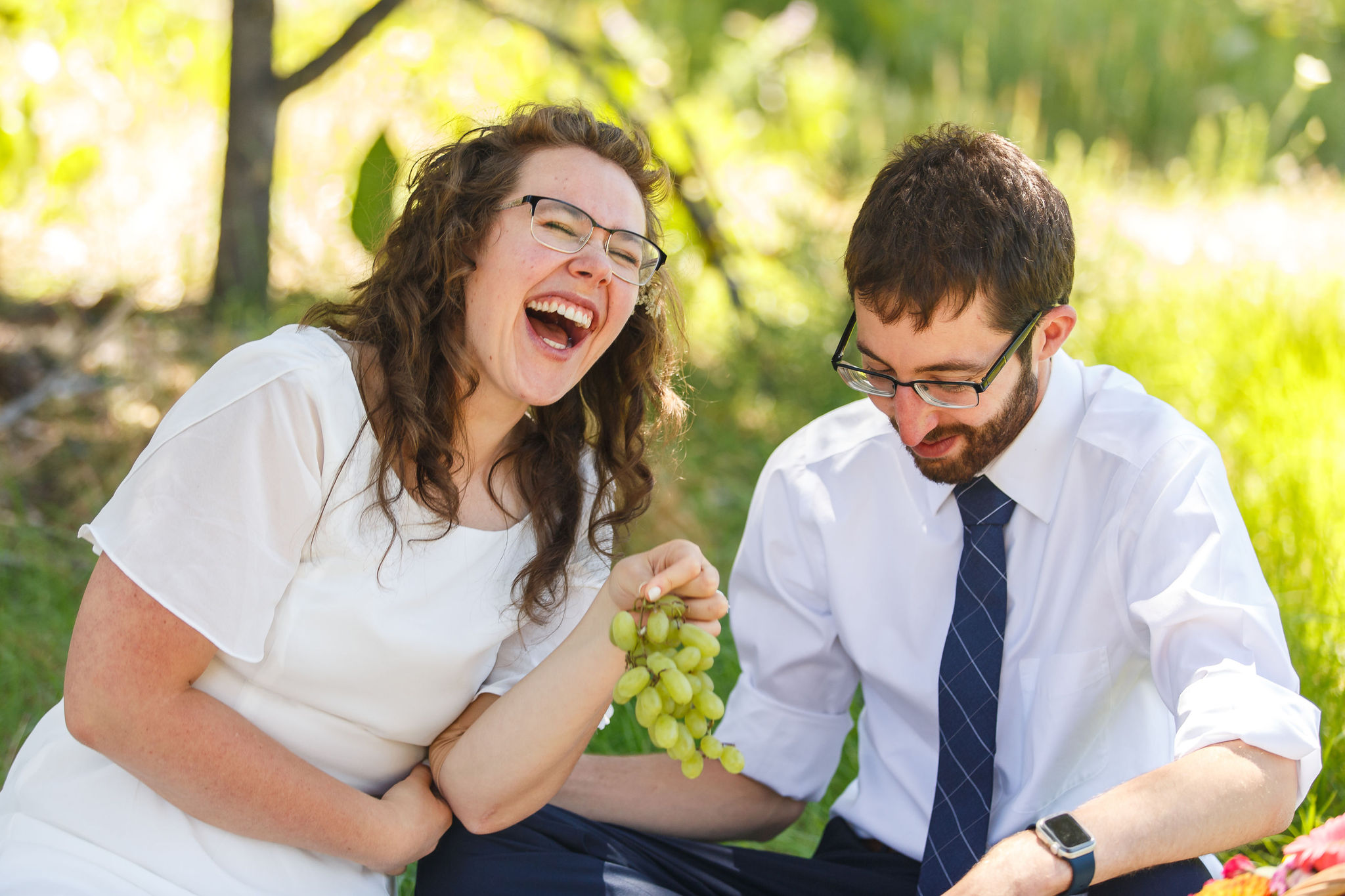 newly weds laughing together as they enjoy an picnic as an Elopement Activity after their ceremony