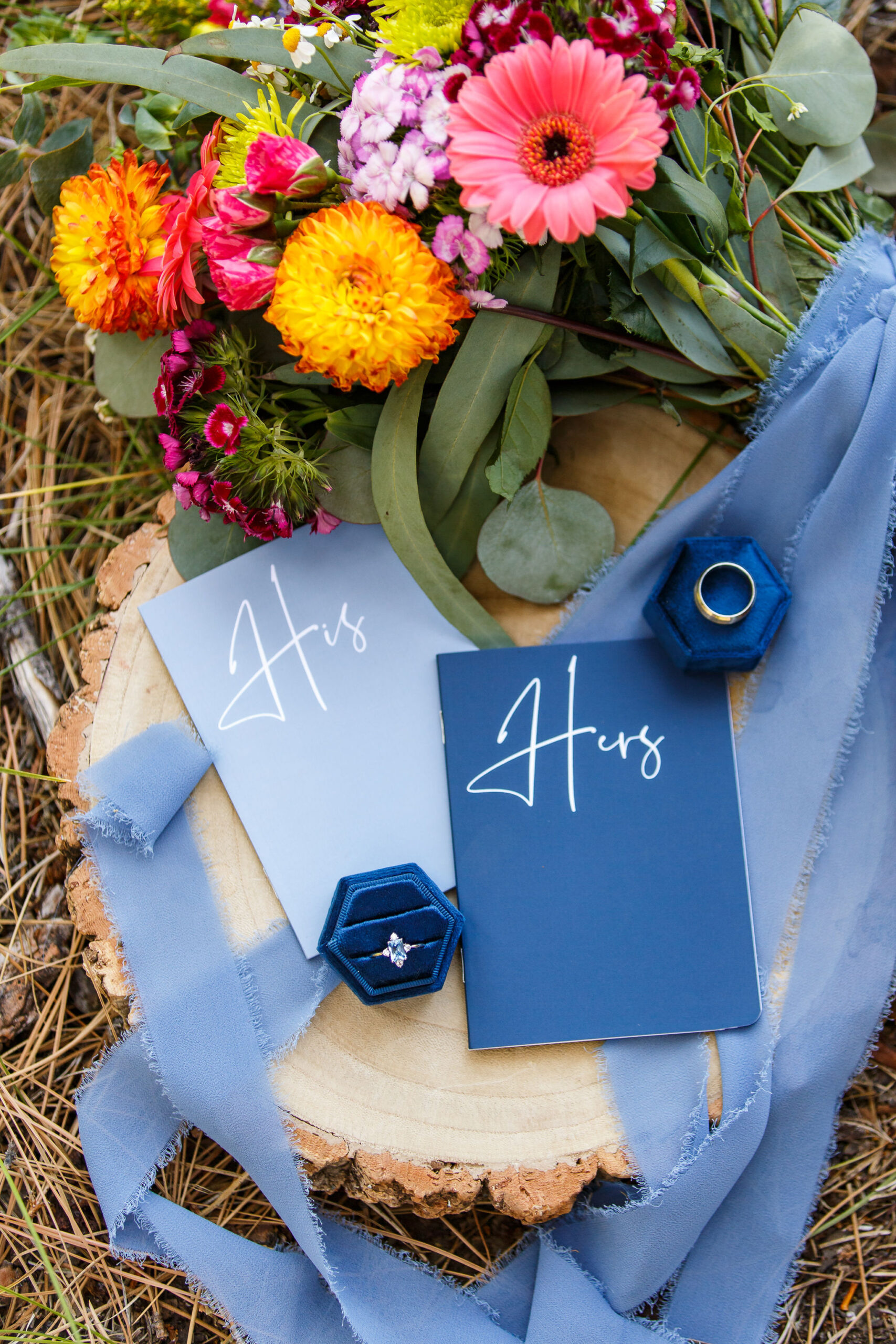 elopement details, colorful flowers, rings and vow books 