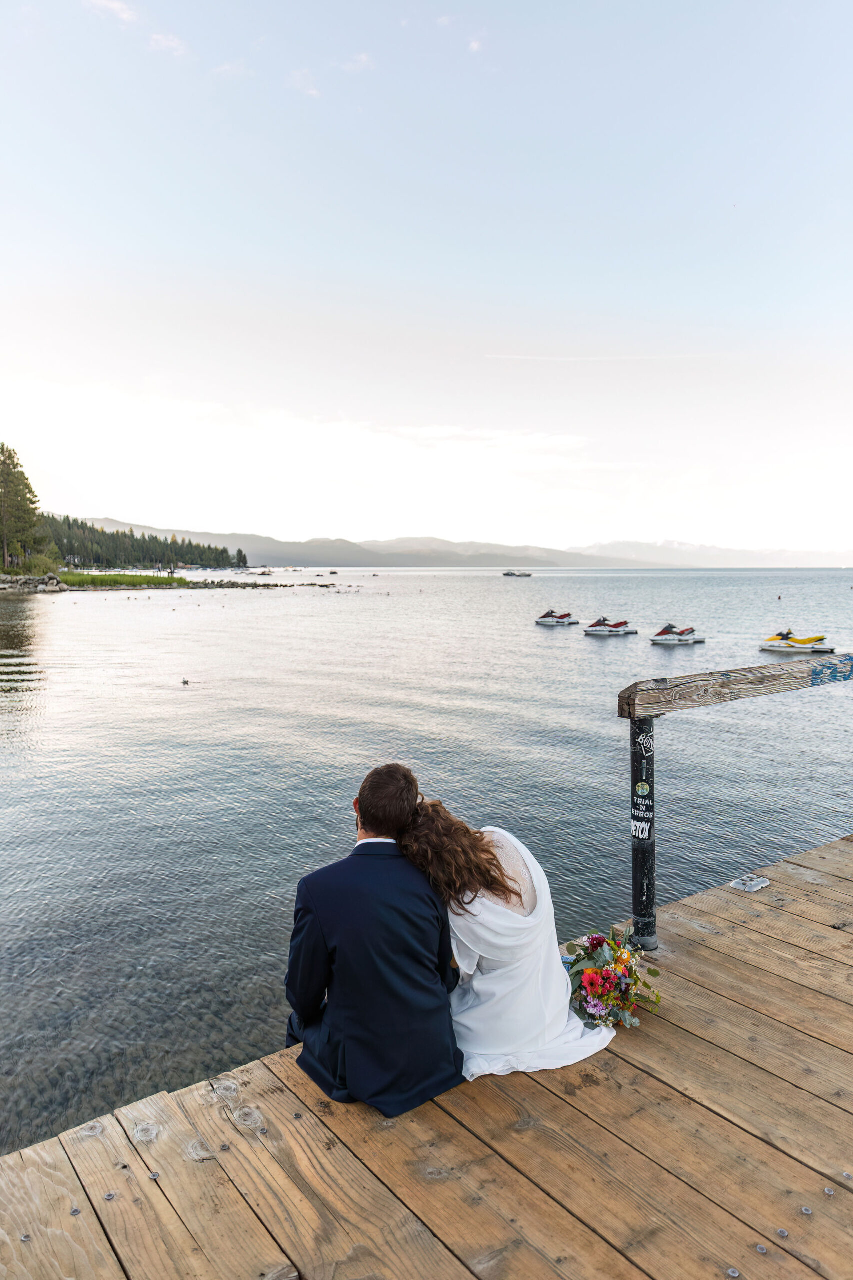 a couple sitting on a dock looking out at Lake Tahoe as one of their Elopement Activities