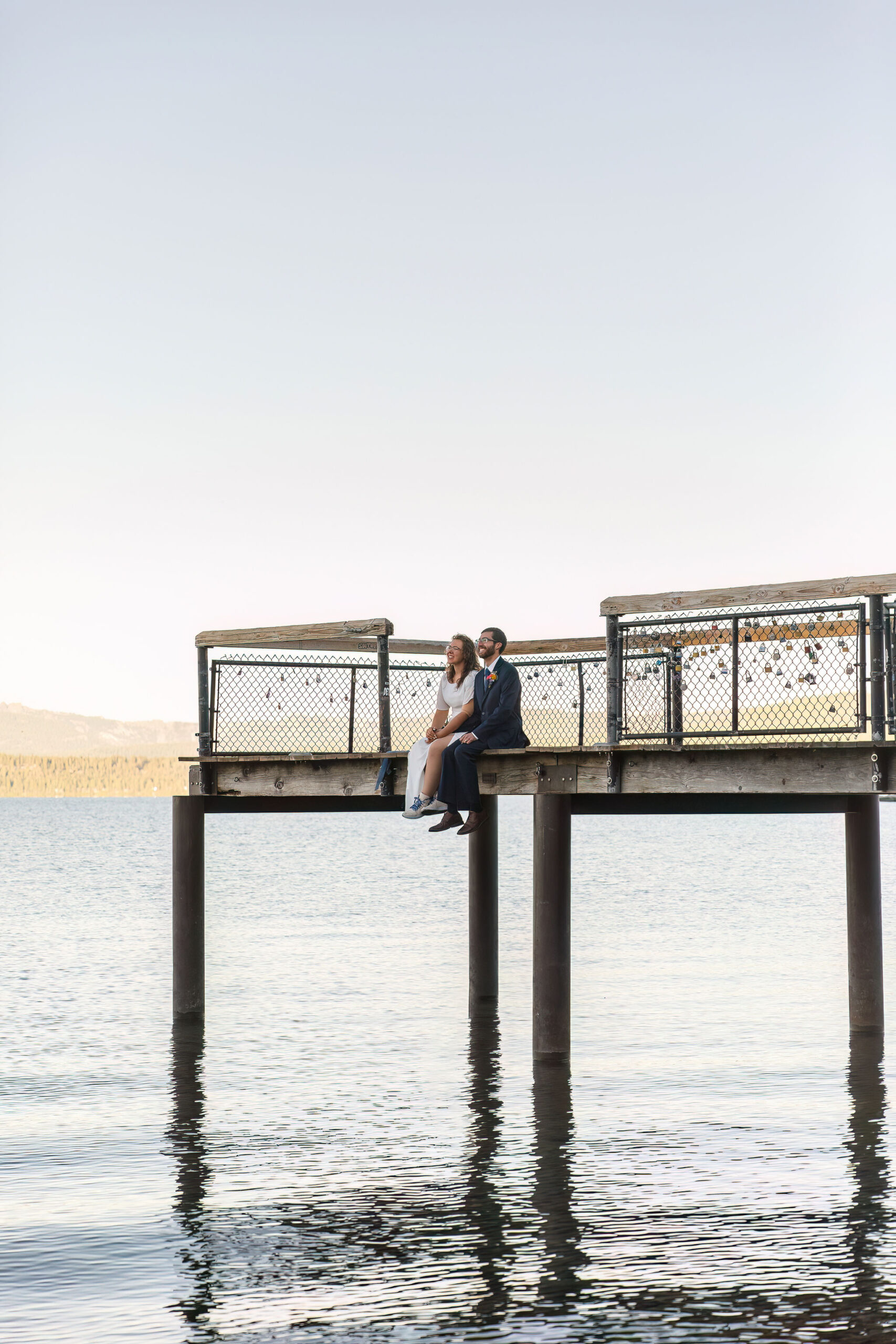 bride and groom sitting on a doc together as one of their Elopement Activities