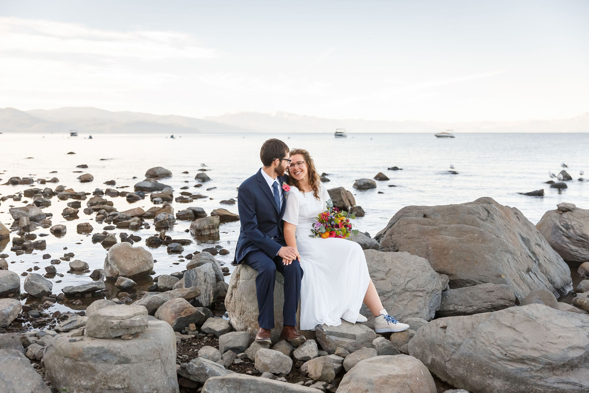 newly weds sitting on the rocky beach at Lake Tahoe as an Elopement Activity 