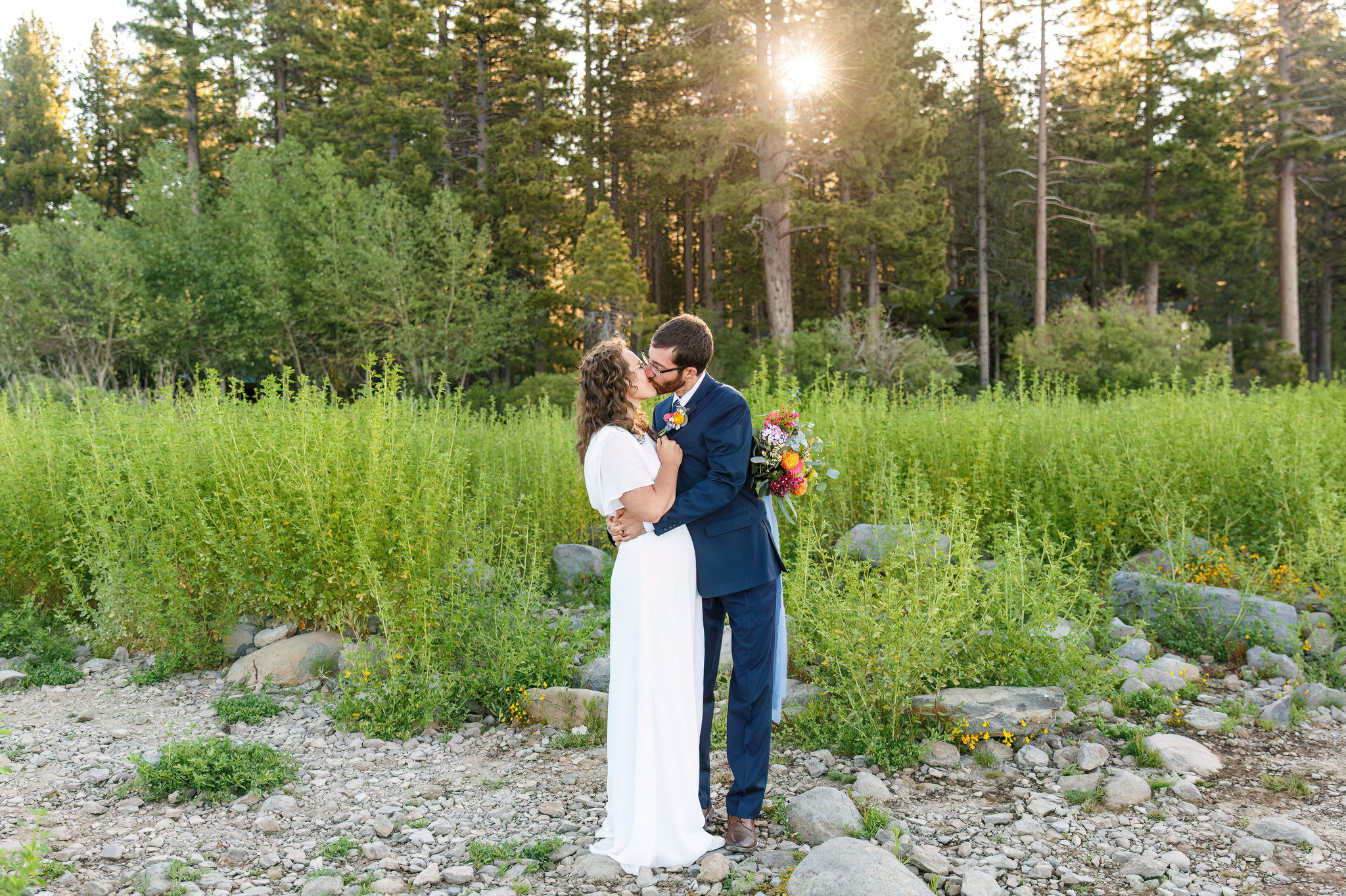 bride and groom kissing in a flower field 