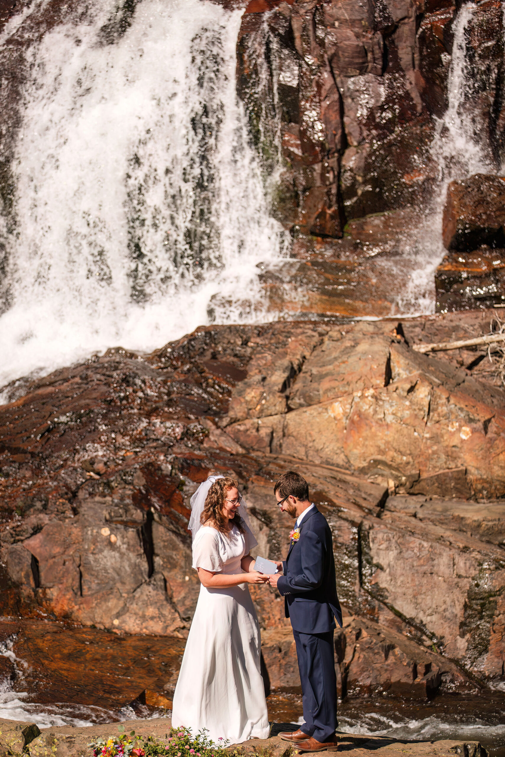 a couple saying their vows next to a waterfall in Lake Tahoe 