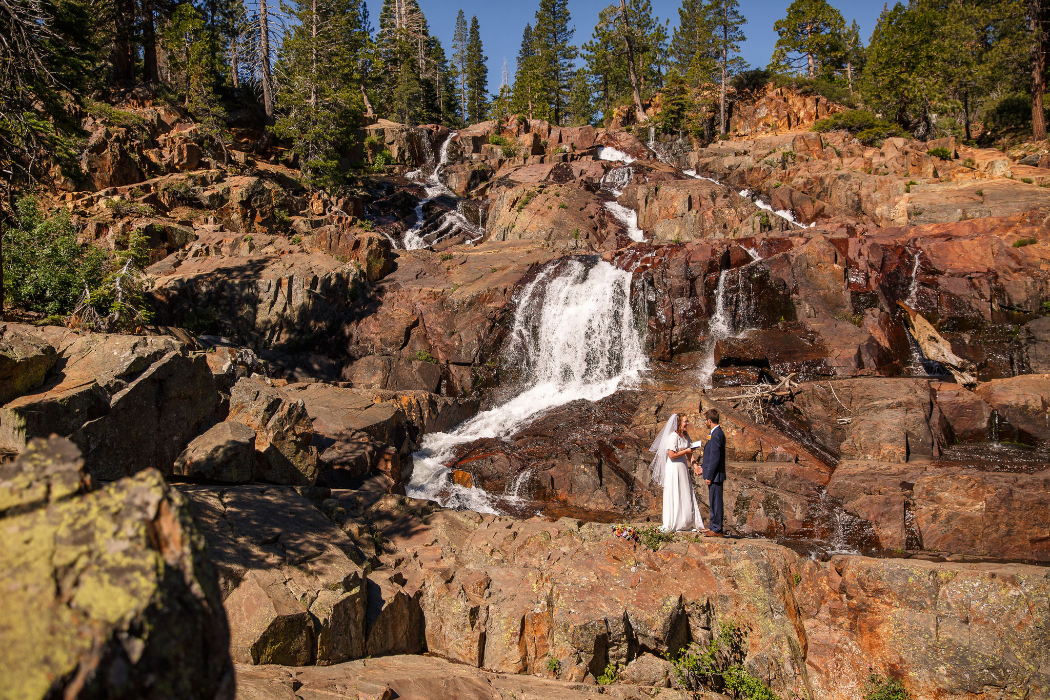 a couple saying their vows privately in front of a waterfall in Lake Tahoe 