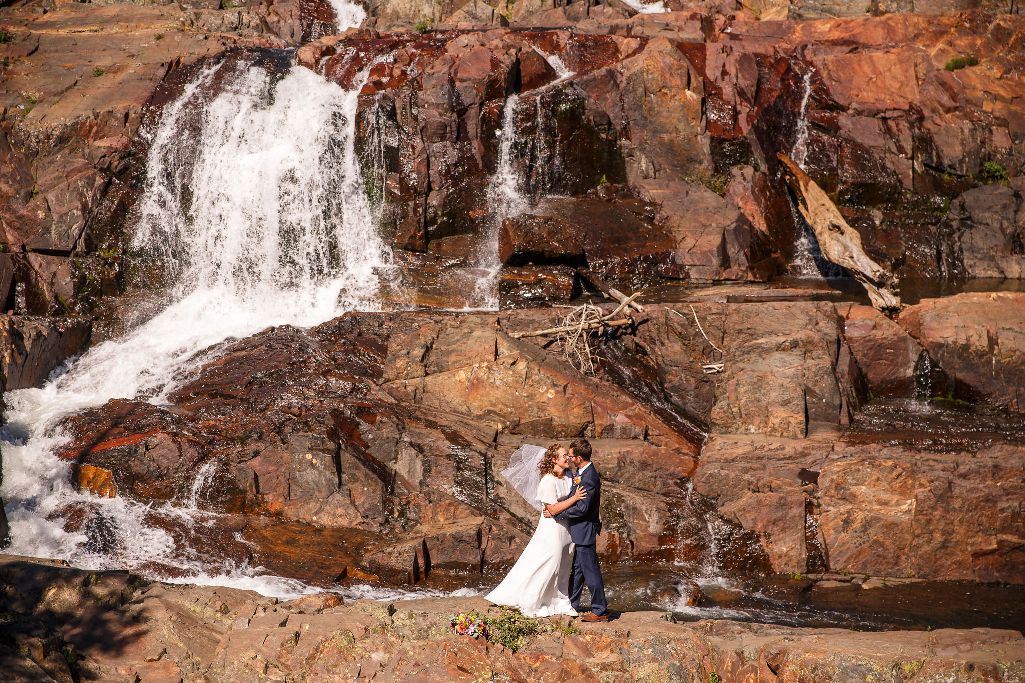 a couple having an elopement next to a roaring waterfall in Lake Tahoe 