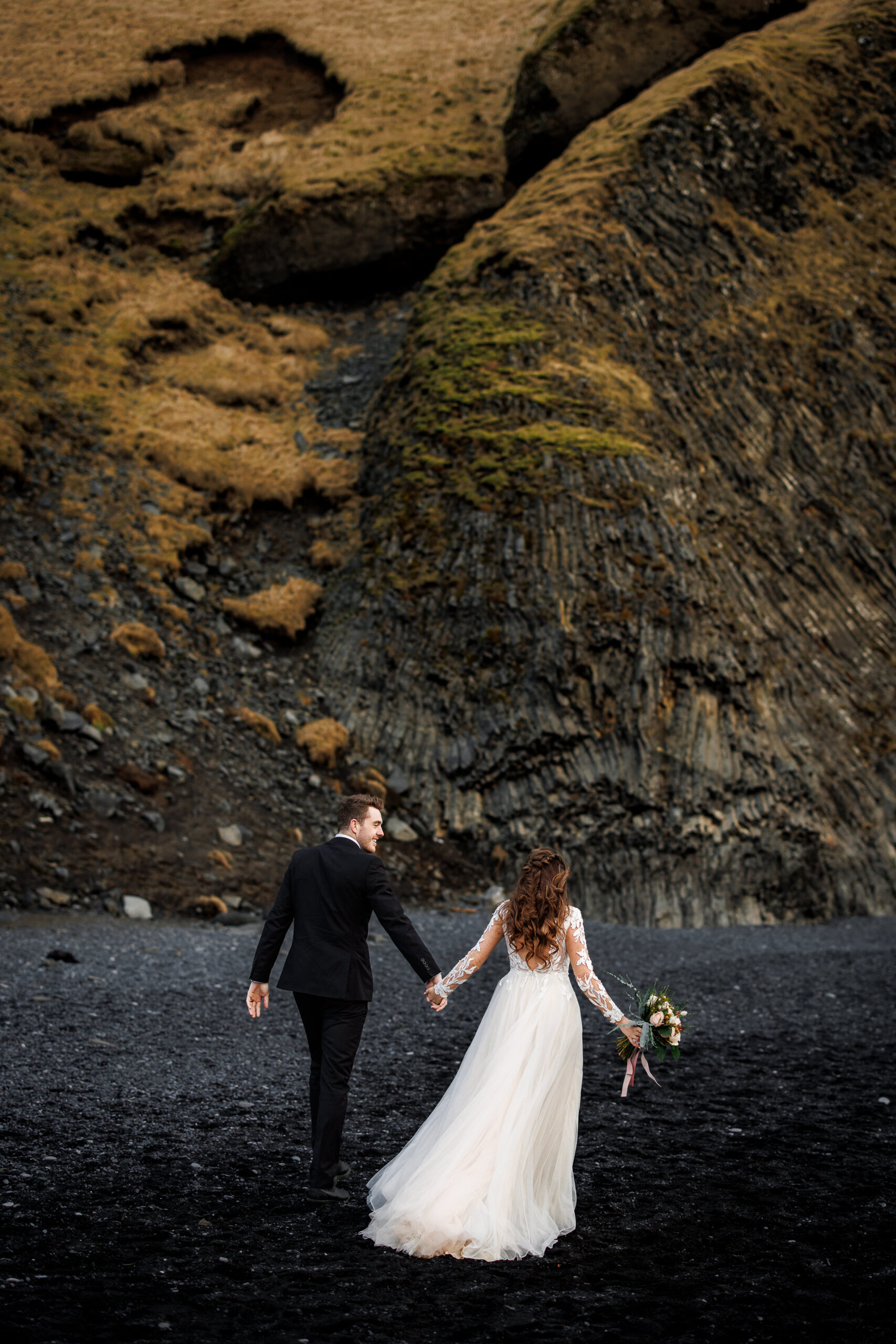 bride and groom on the black sand beac in Iceland during their winter elopement