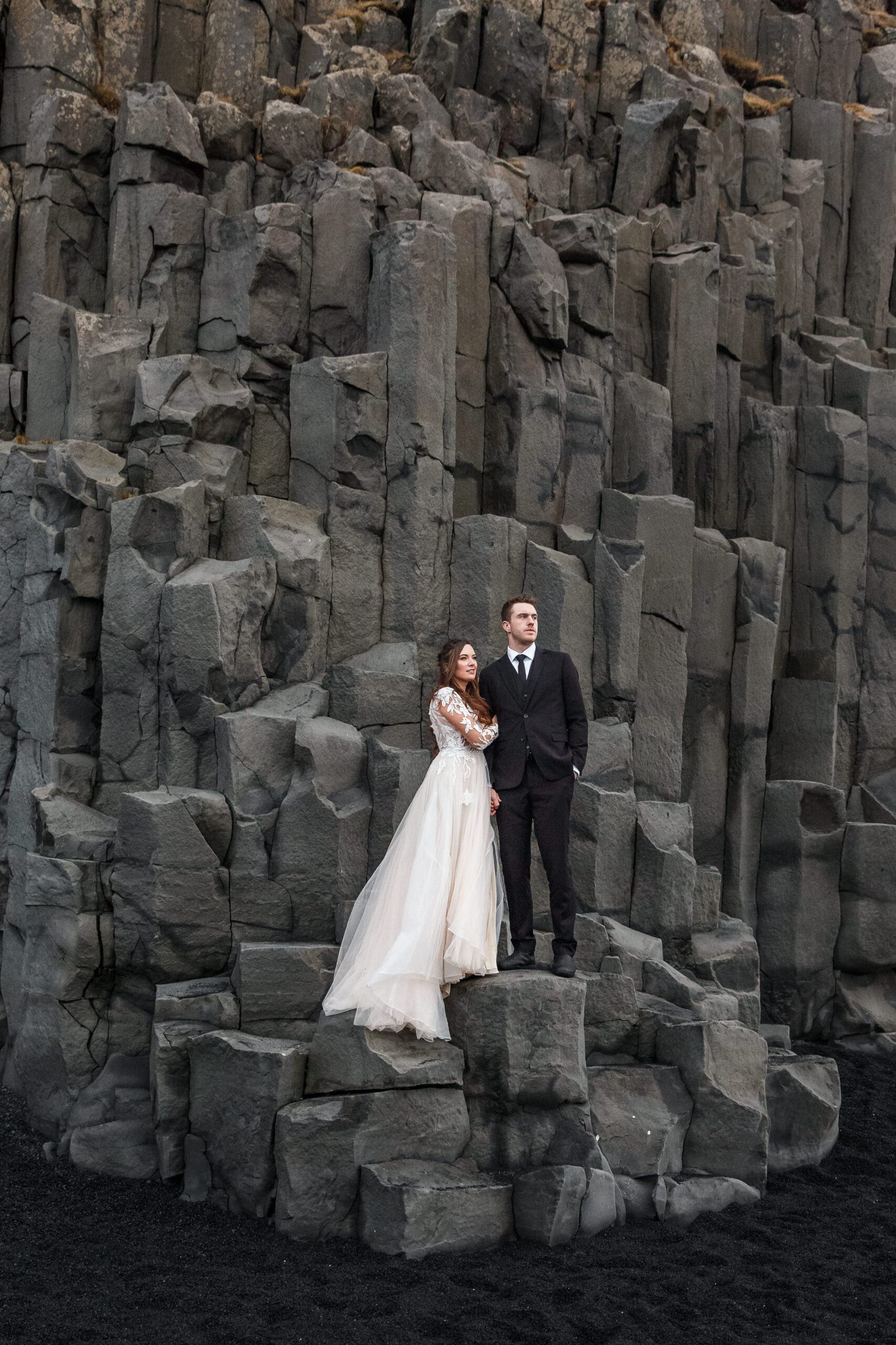 bridal couple portraits standing on black rock and the black sand beach 