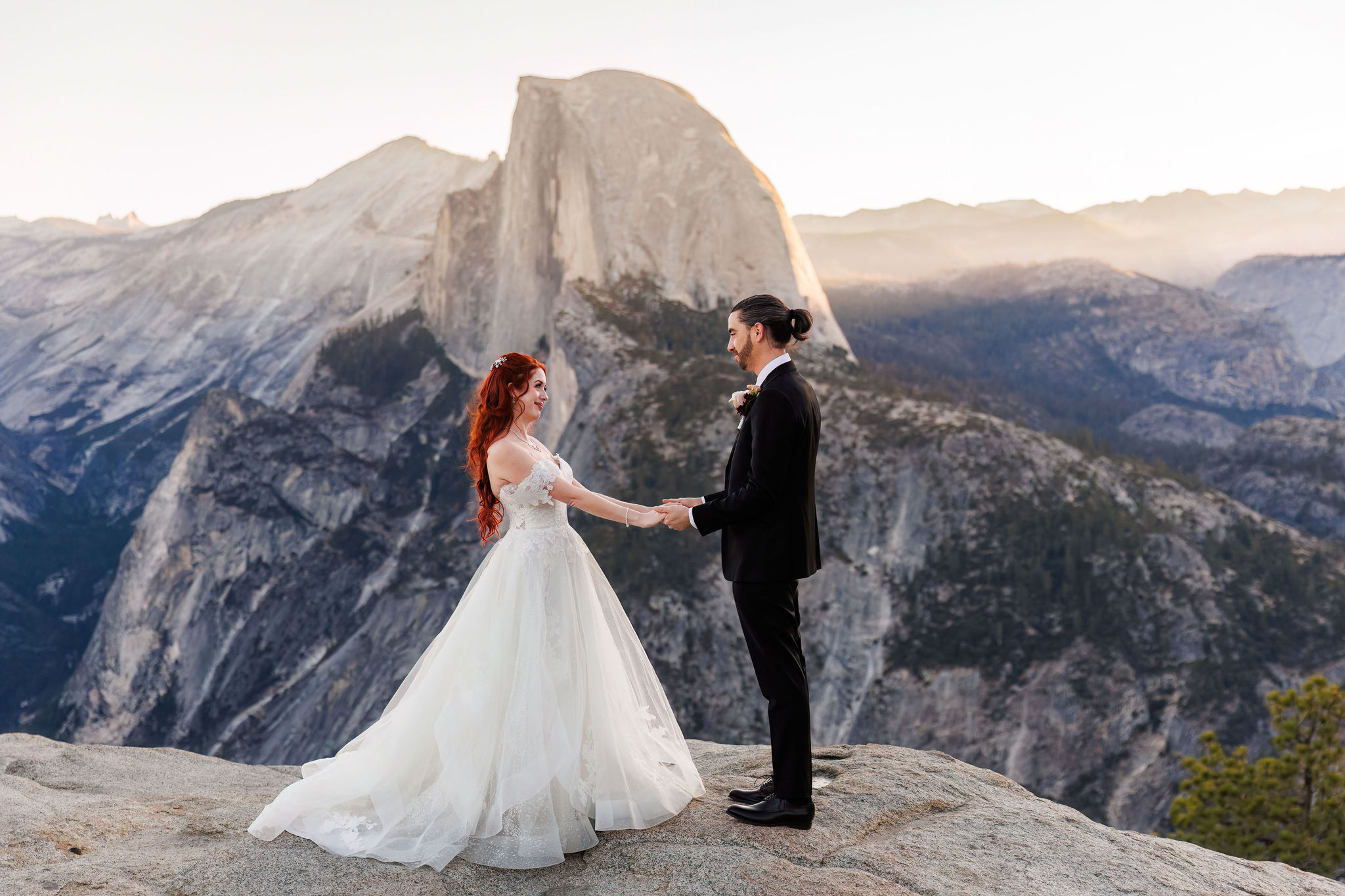 bride and groom holding hands and smiling with each other 