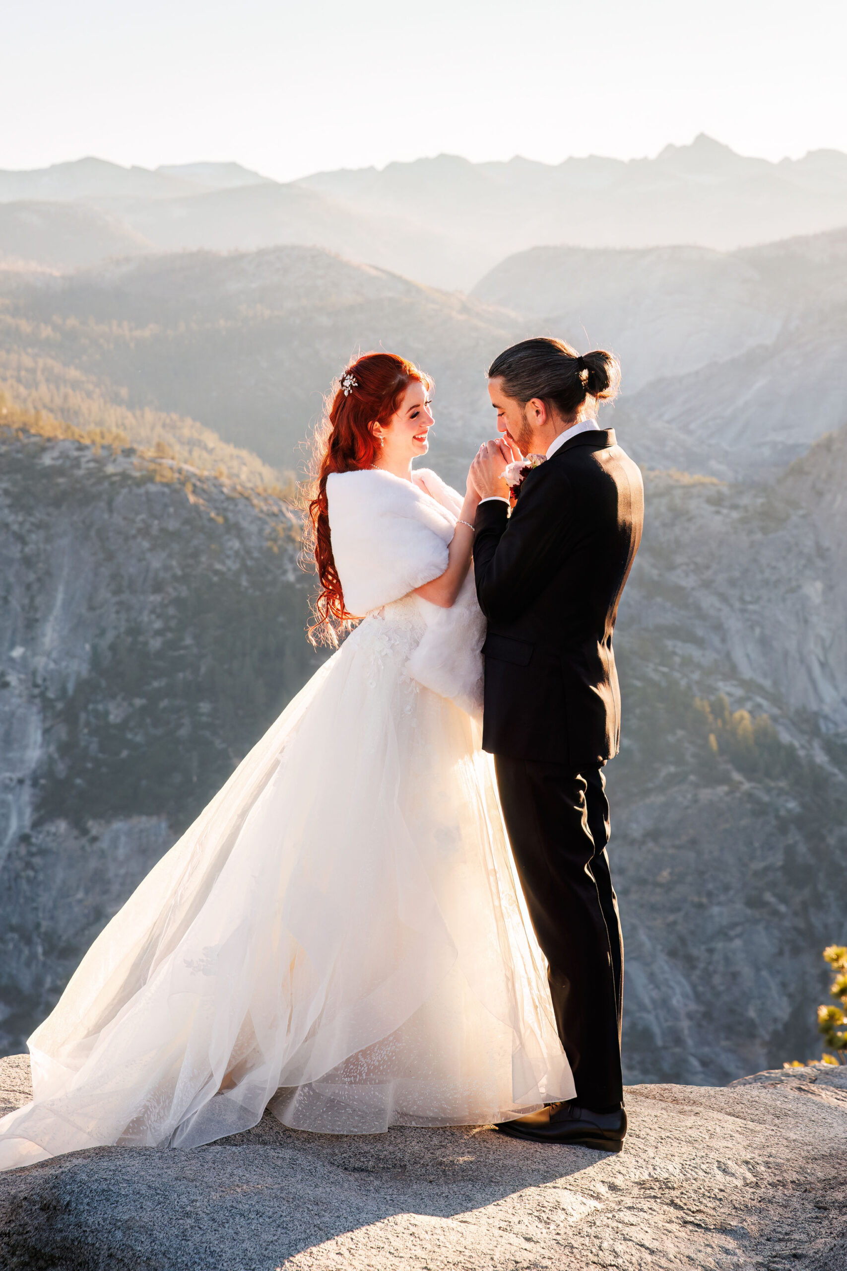 groom holding and kissing bride's hands 