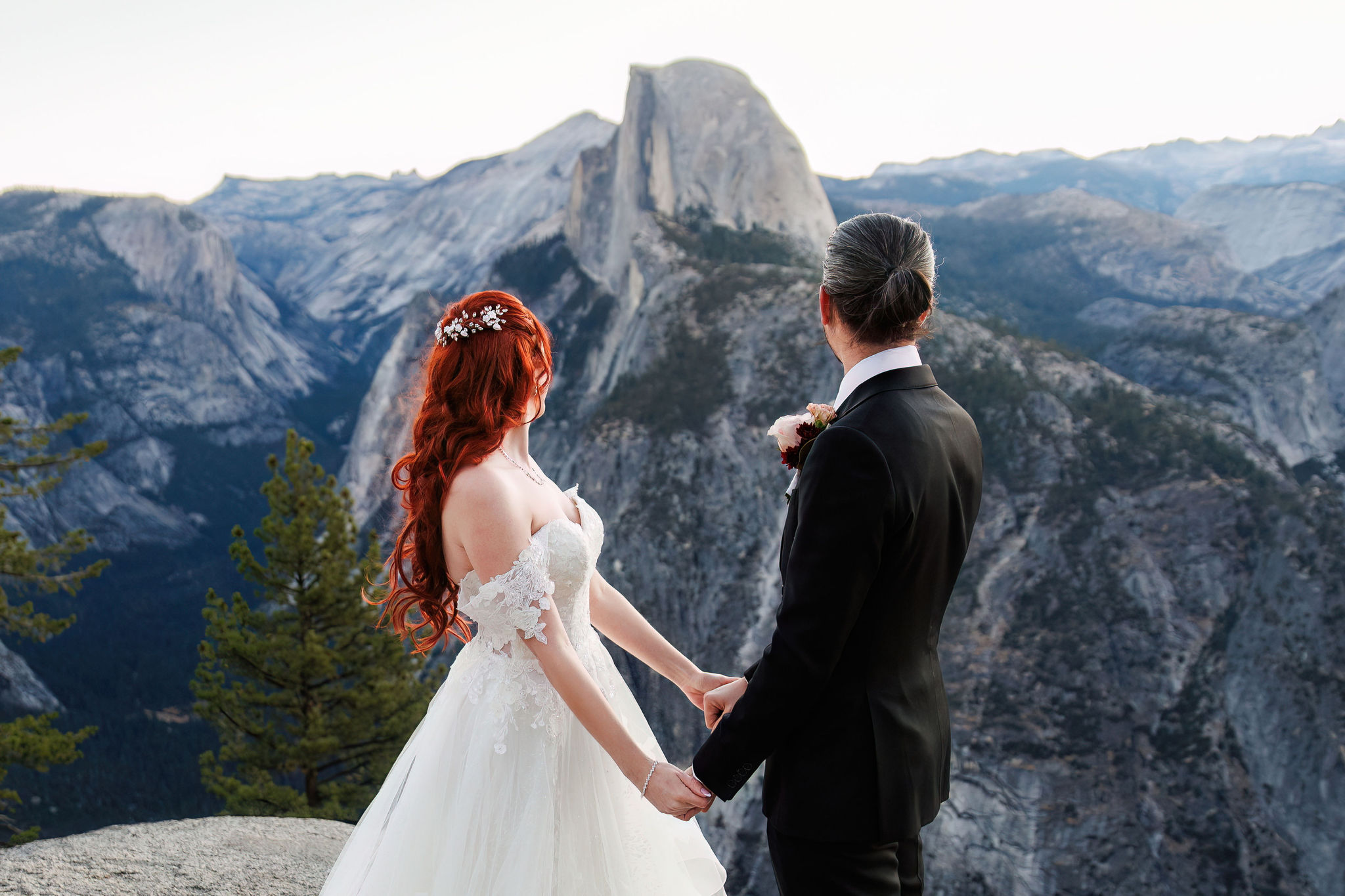 bride and groom holding hands and looking out at the view 