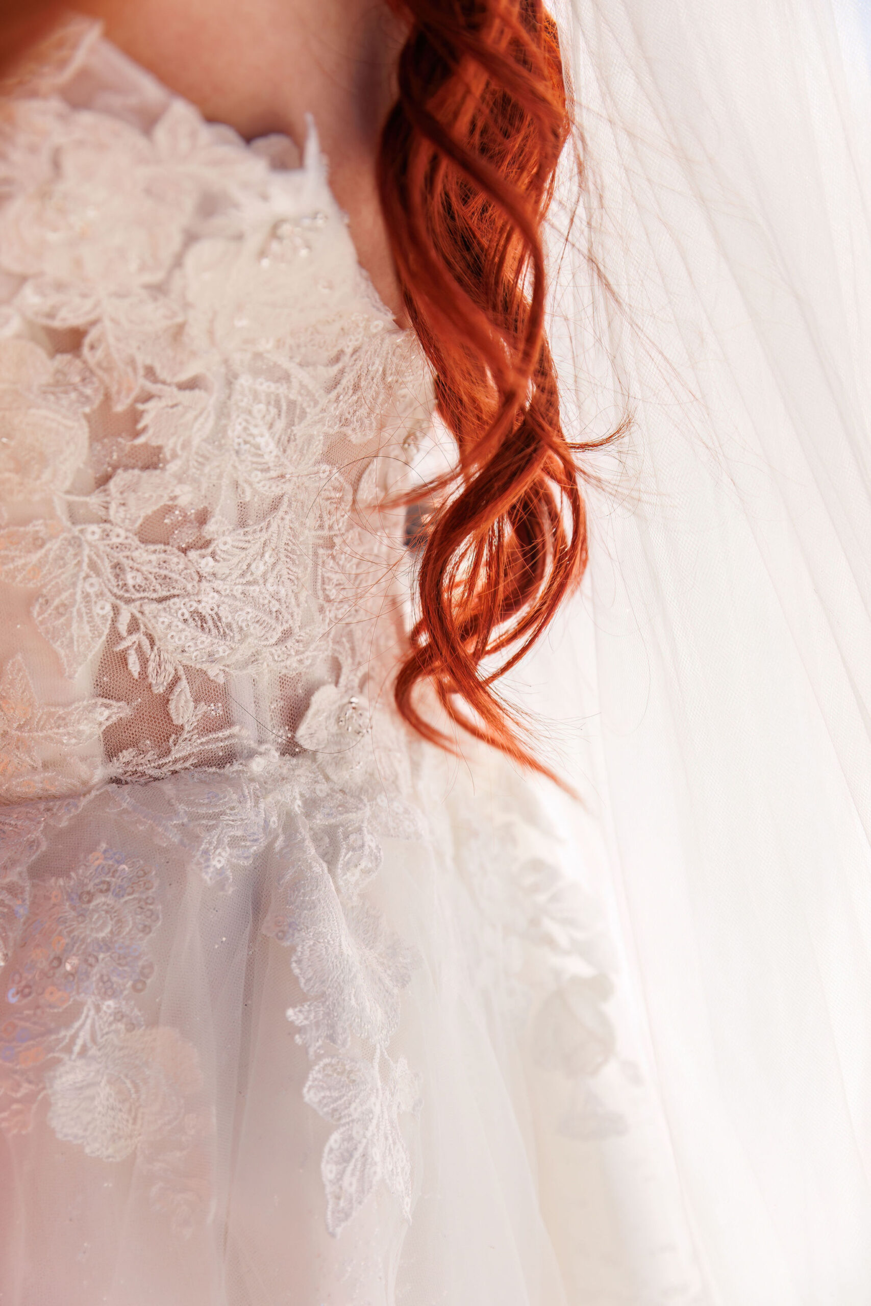 bridal details of her dress and red hair 