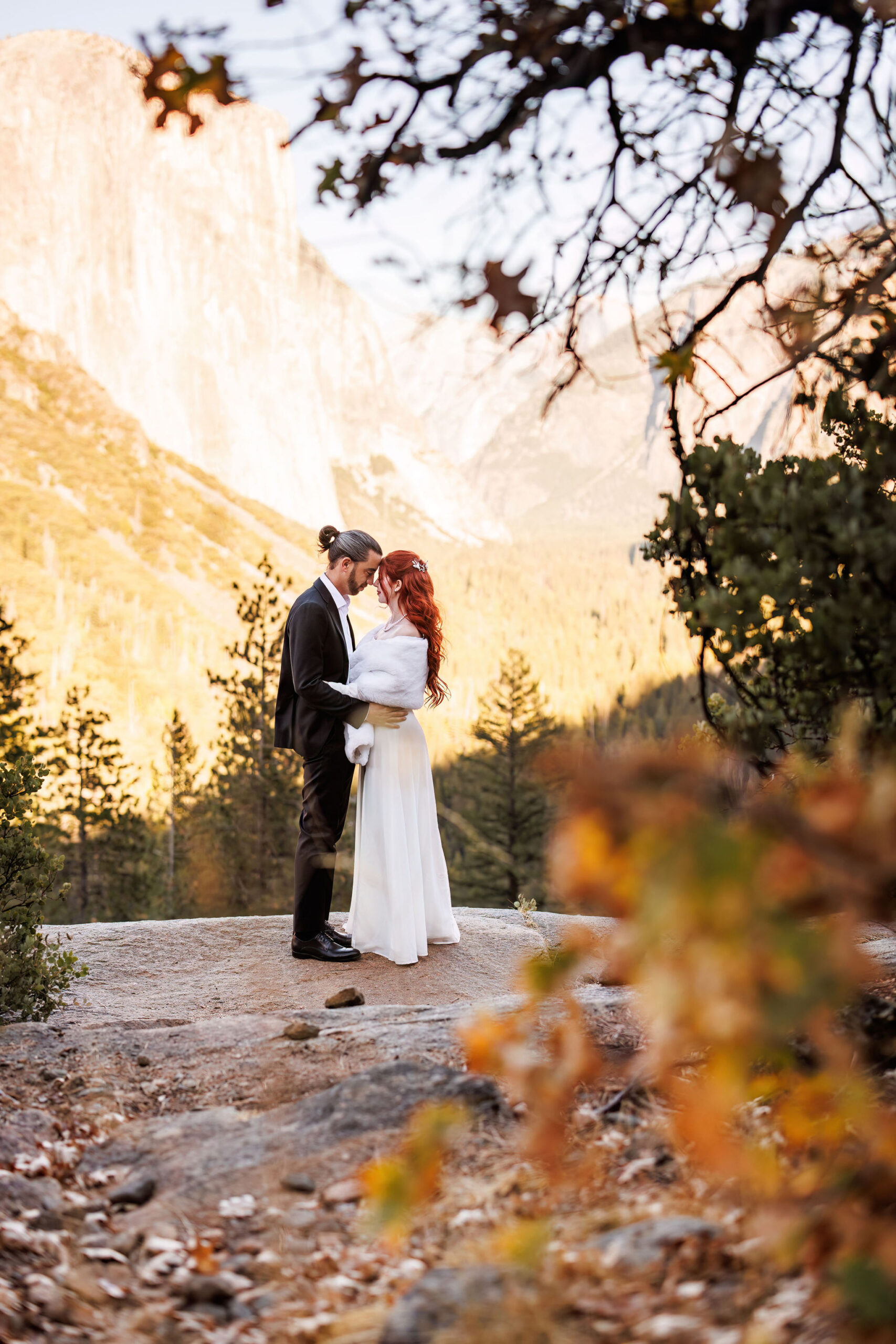 bridal couple in the fall colored trees 