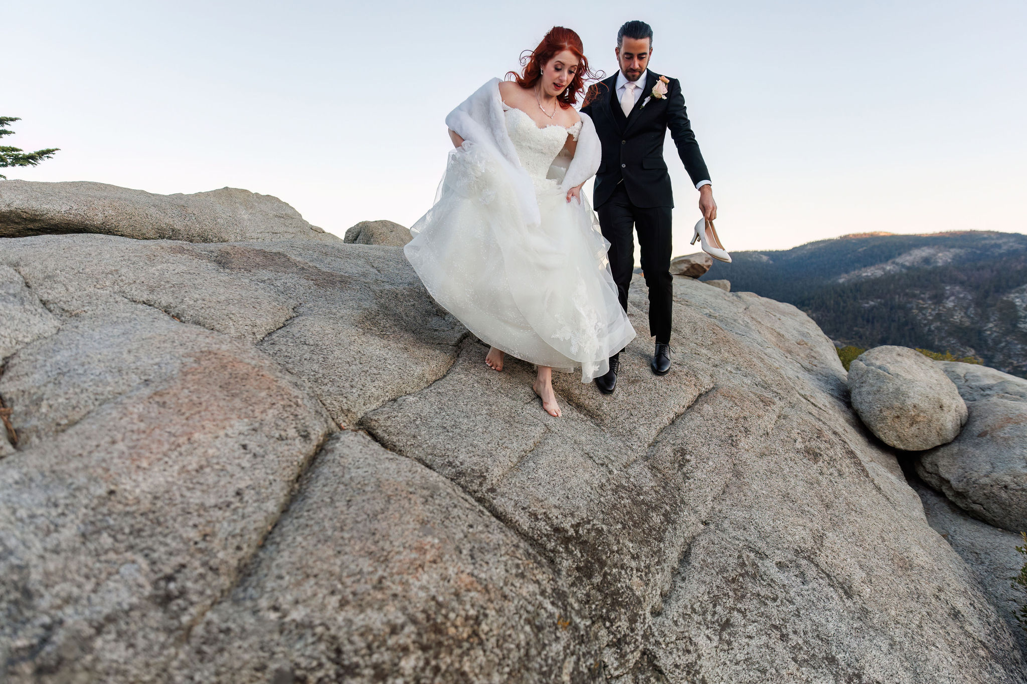 bride walking barefoot on the rocks 