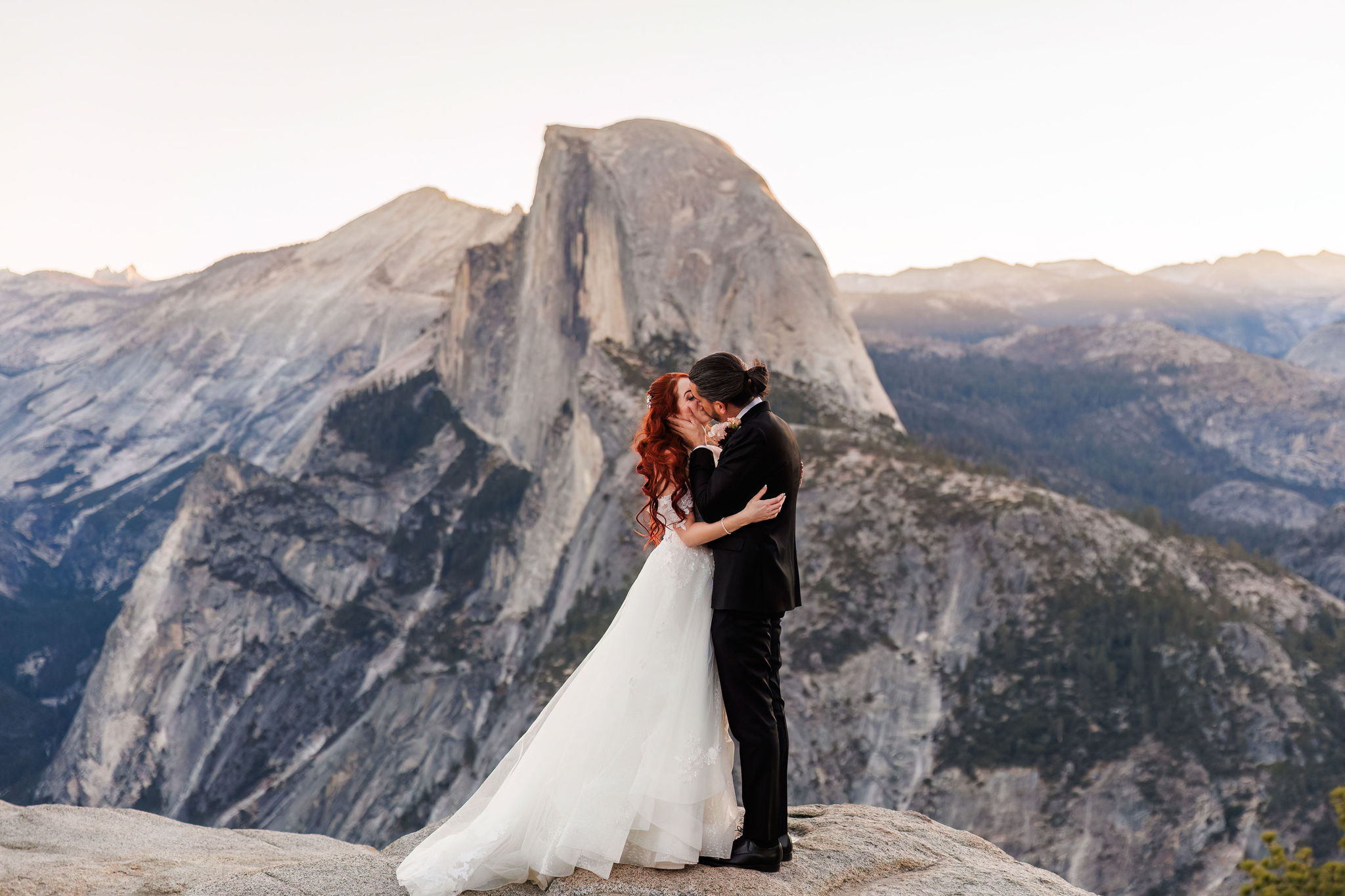 bride and groom kissing with a view 