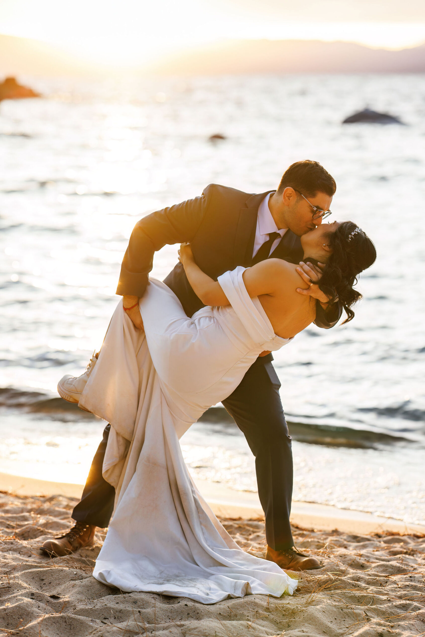 groom dipping the bride on the beach 