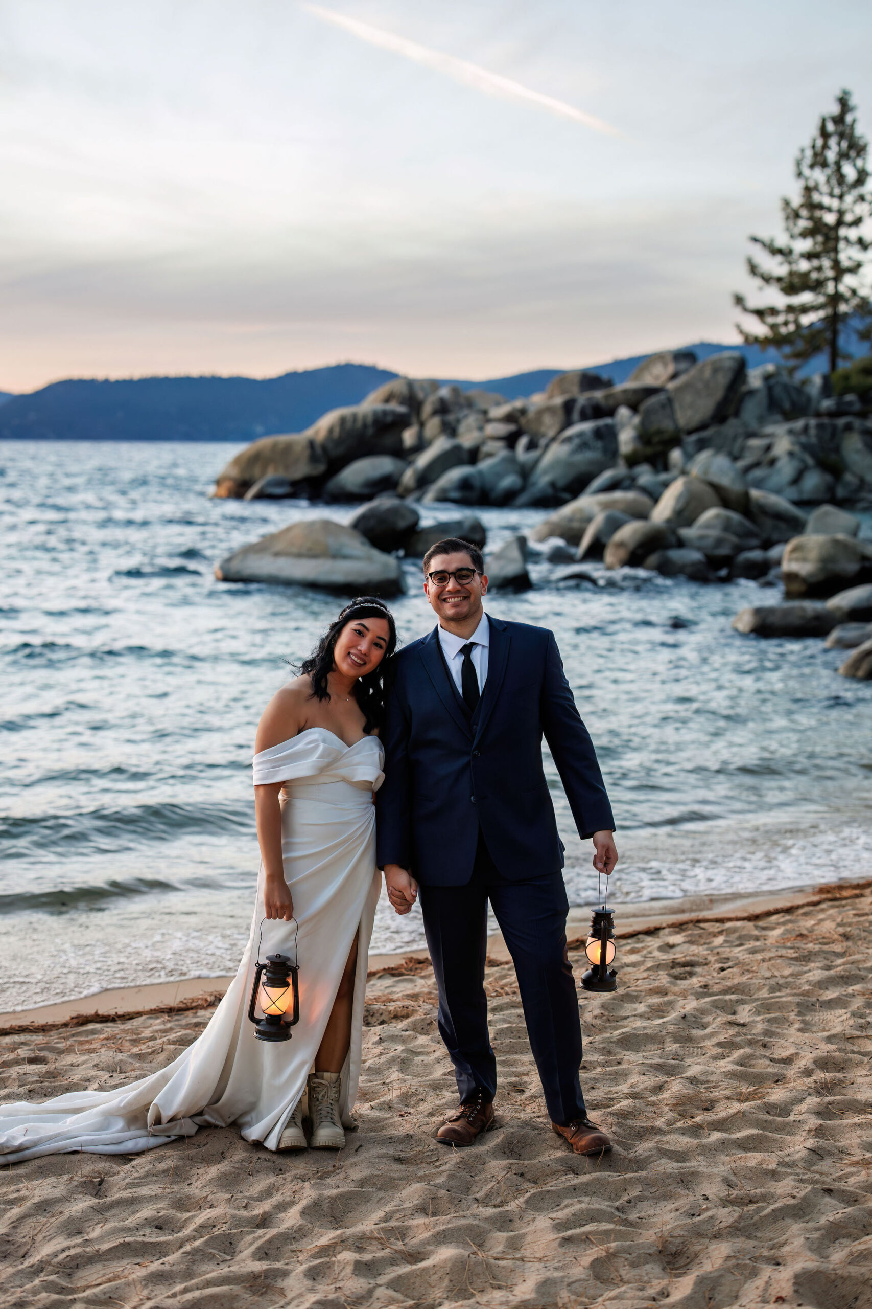 bridal couple smiling on the beach during blue hour 