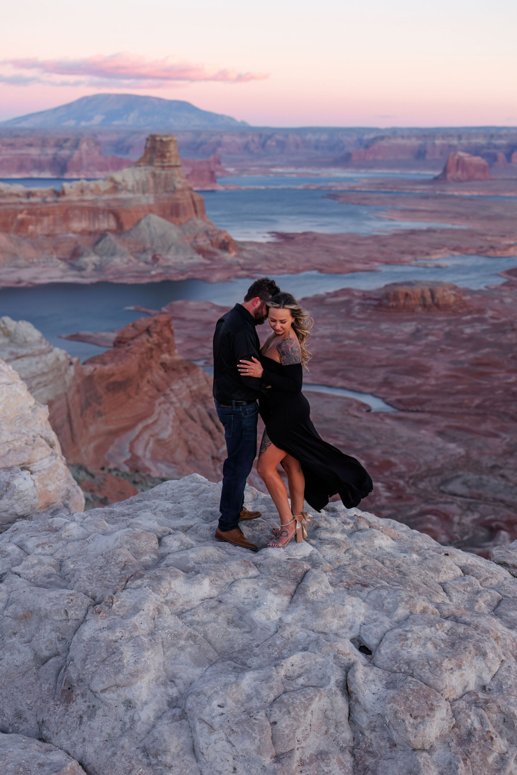 a newly engaged couple standing on a view point at Lake Powell for their Utah engagement photos