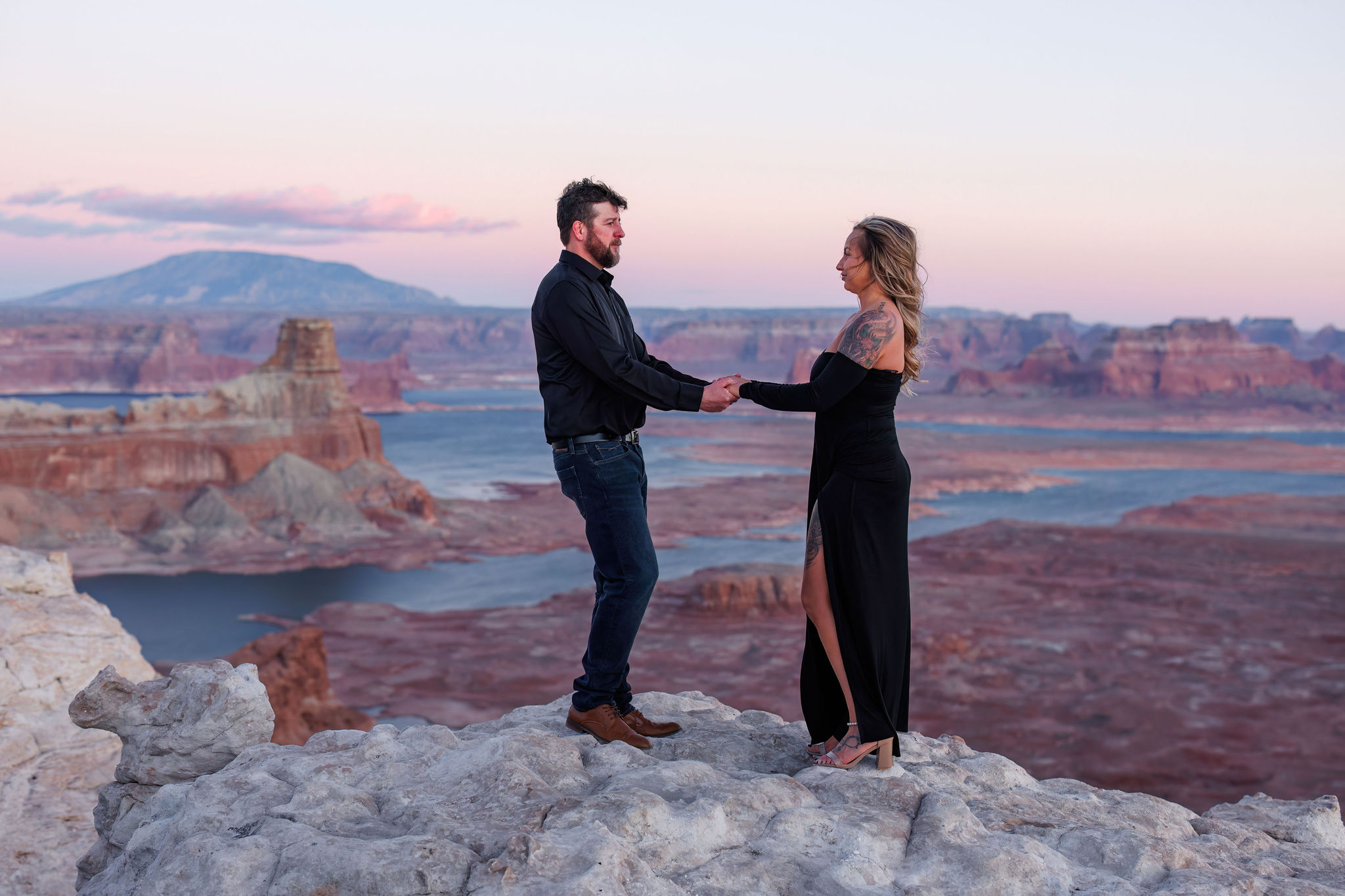 a couple holding hands with the view behind them during their Utah engagement photos