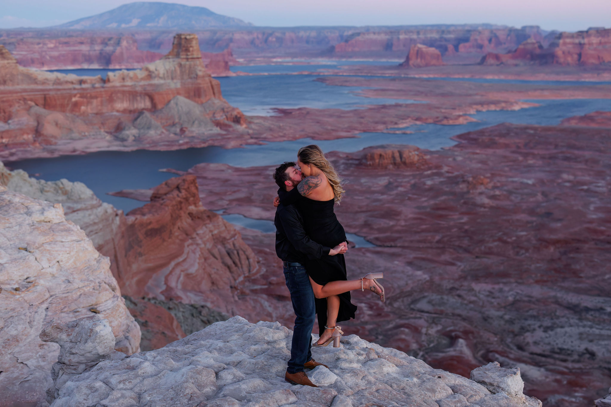 a man holding up a woman at Alstrom Point during sunset 