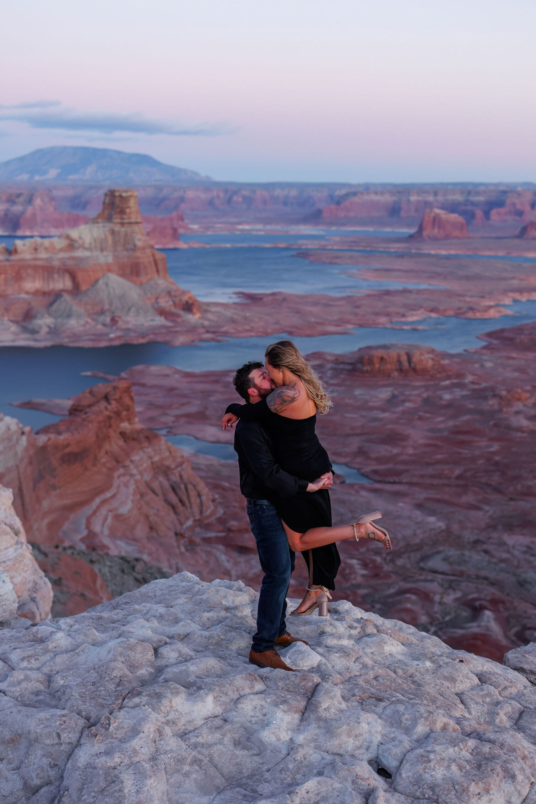 a man holding up a woman during their adventure engagement session in Utah 