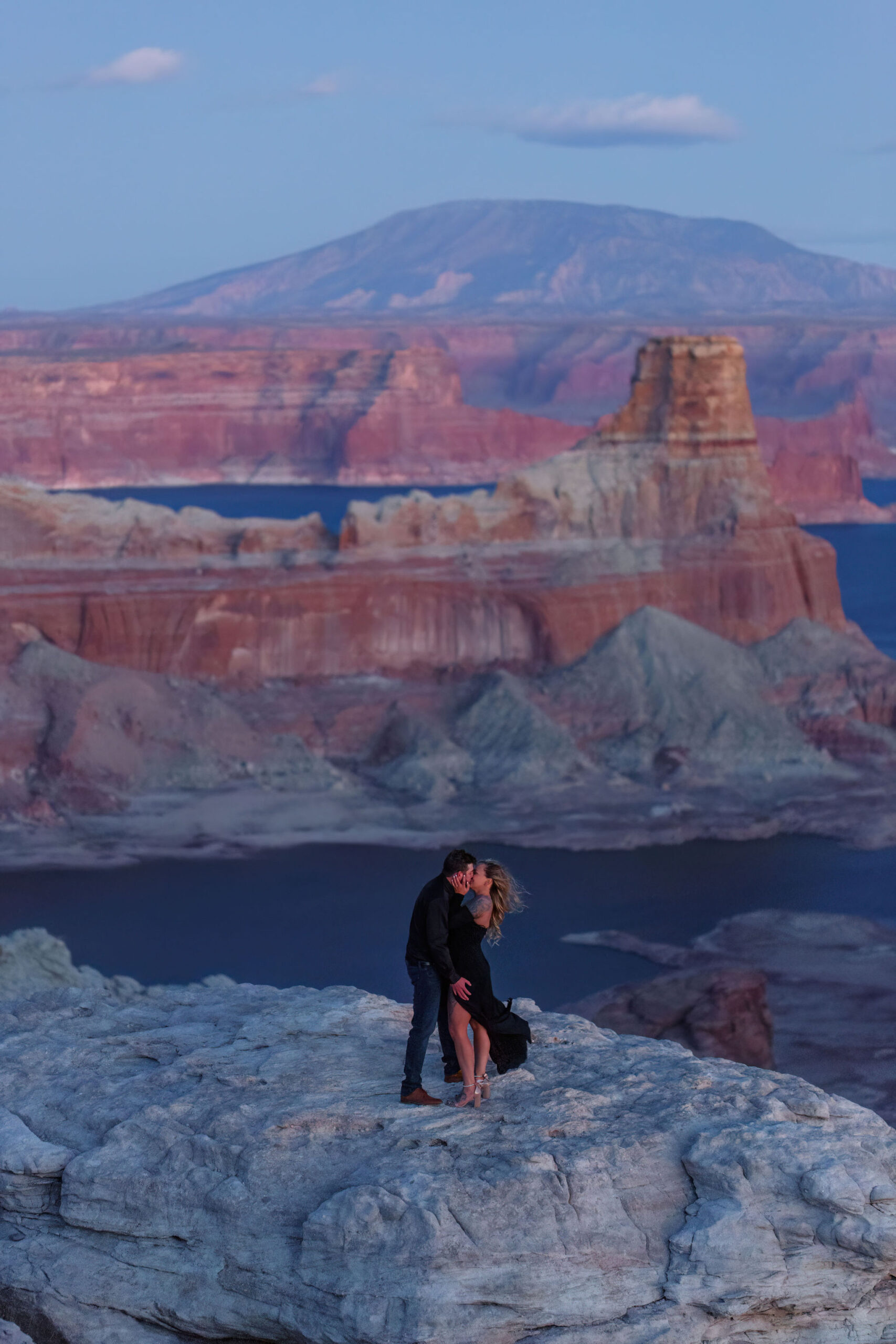 a couple standing at Alstrom Point at sunset for their Utah engagement photos