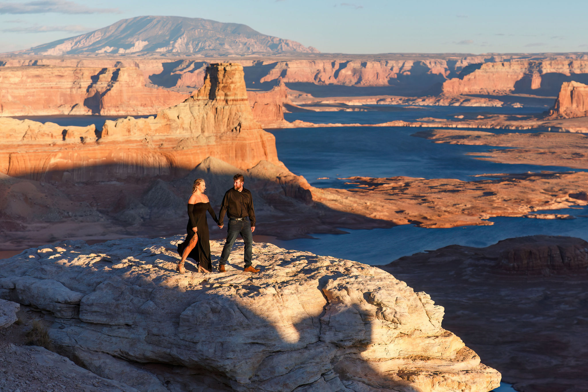 an engaged couple walking along the rocks during their Utah engagement photos