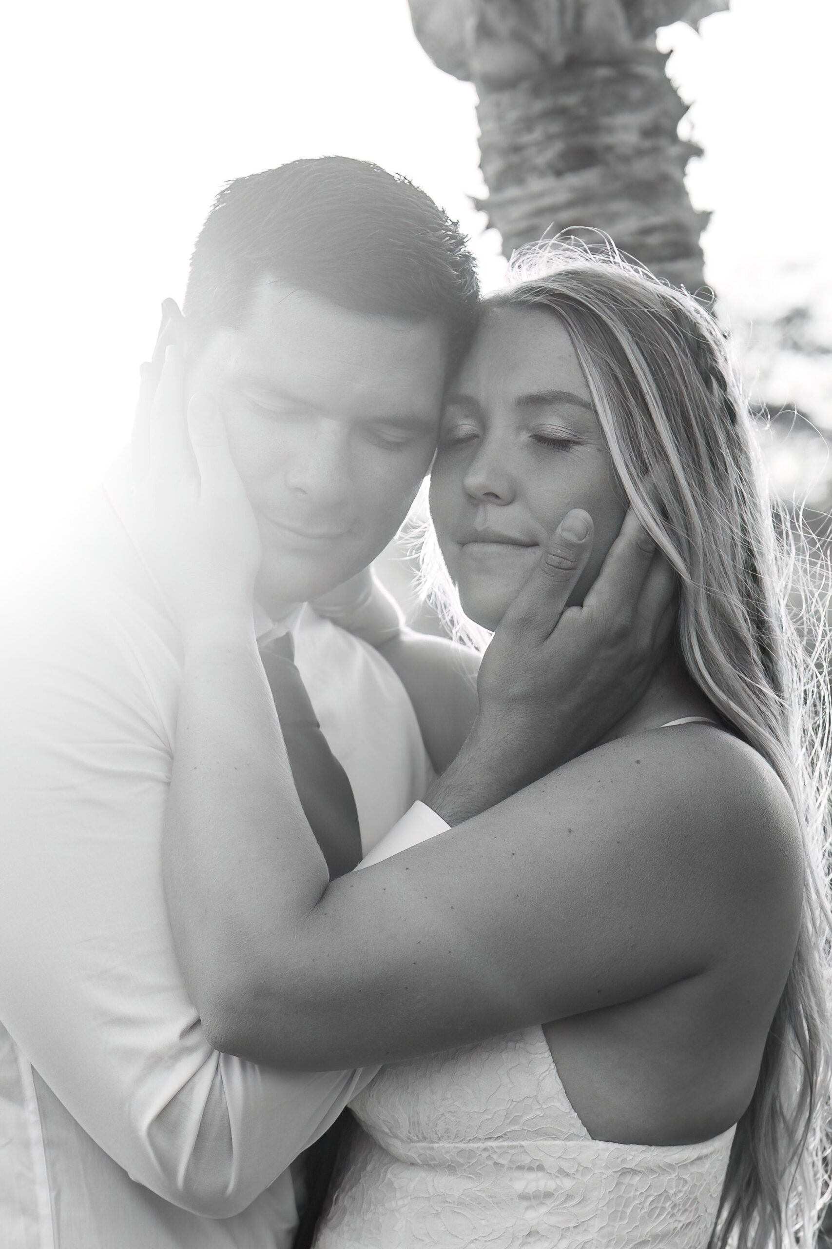 a couple holding each other's face as they close their eyes 