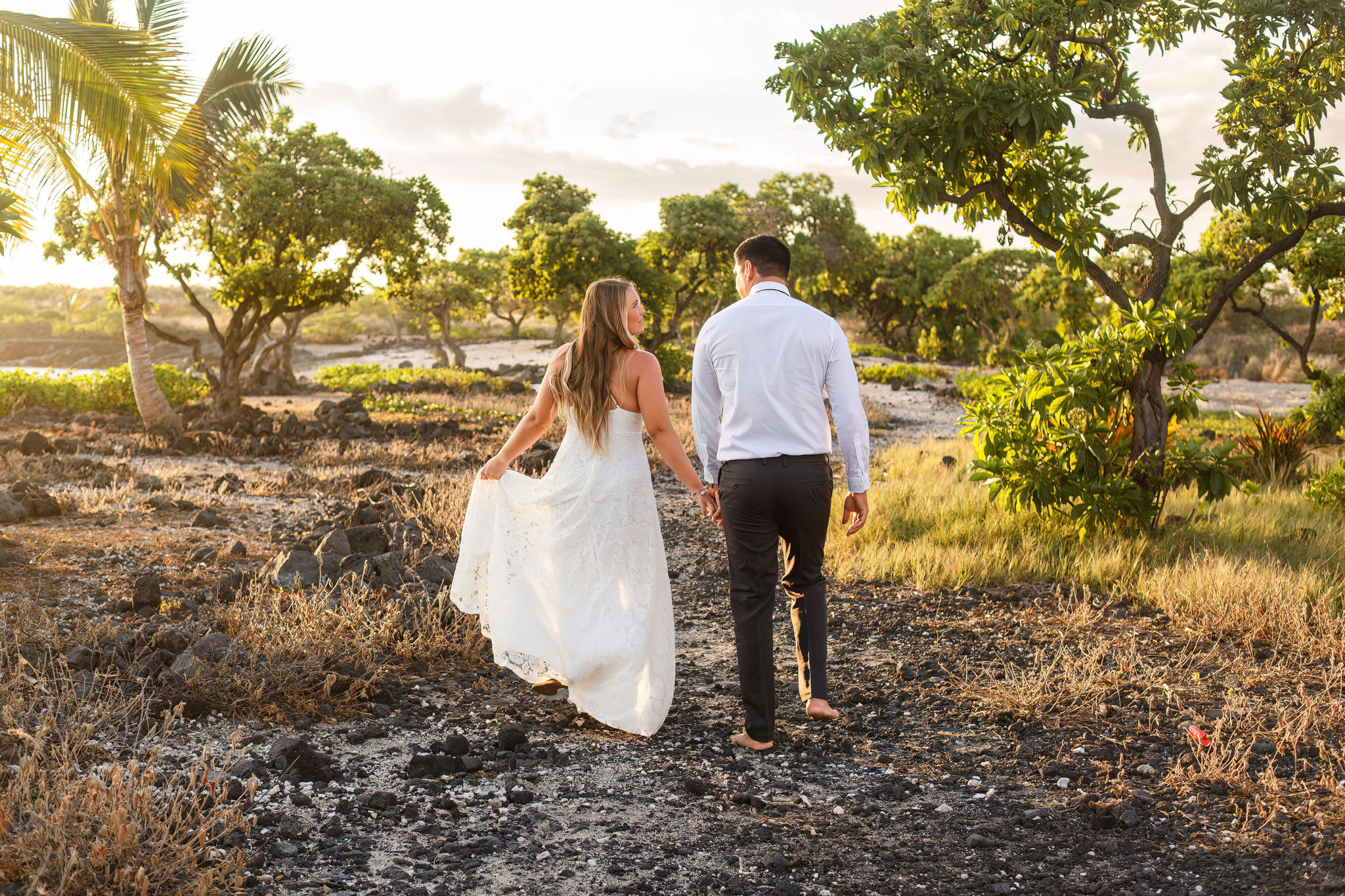 a couple walking through the trees at the beach for their Hawaii elopement 